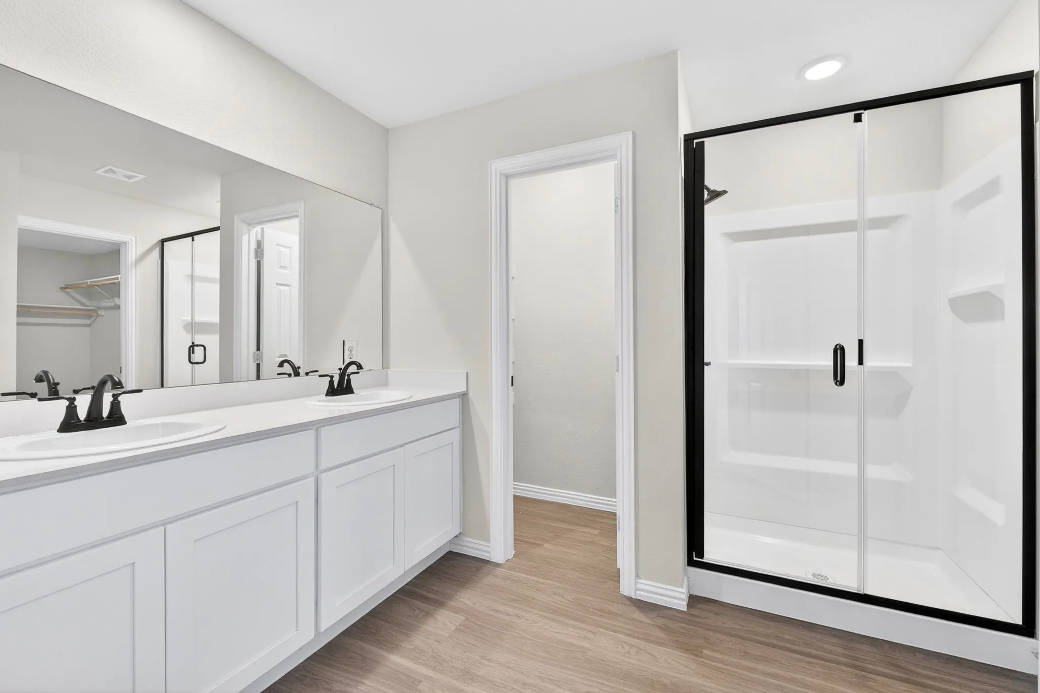 Dual vanity with undermount sinks, matte black fixtures, and a spacious counter