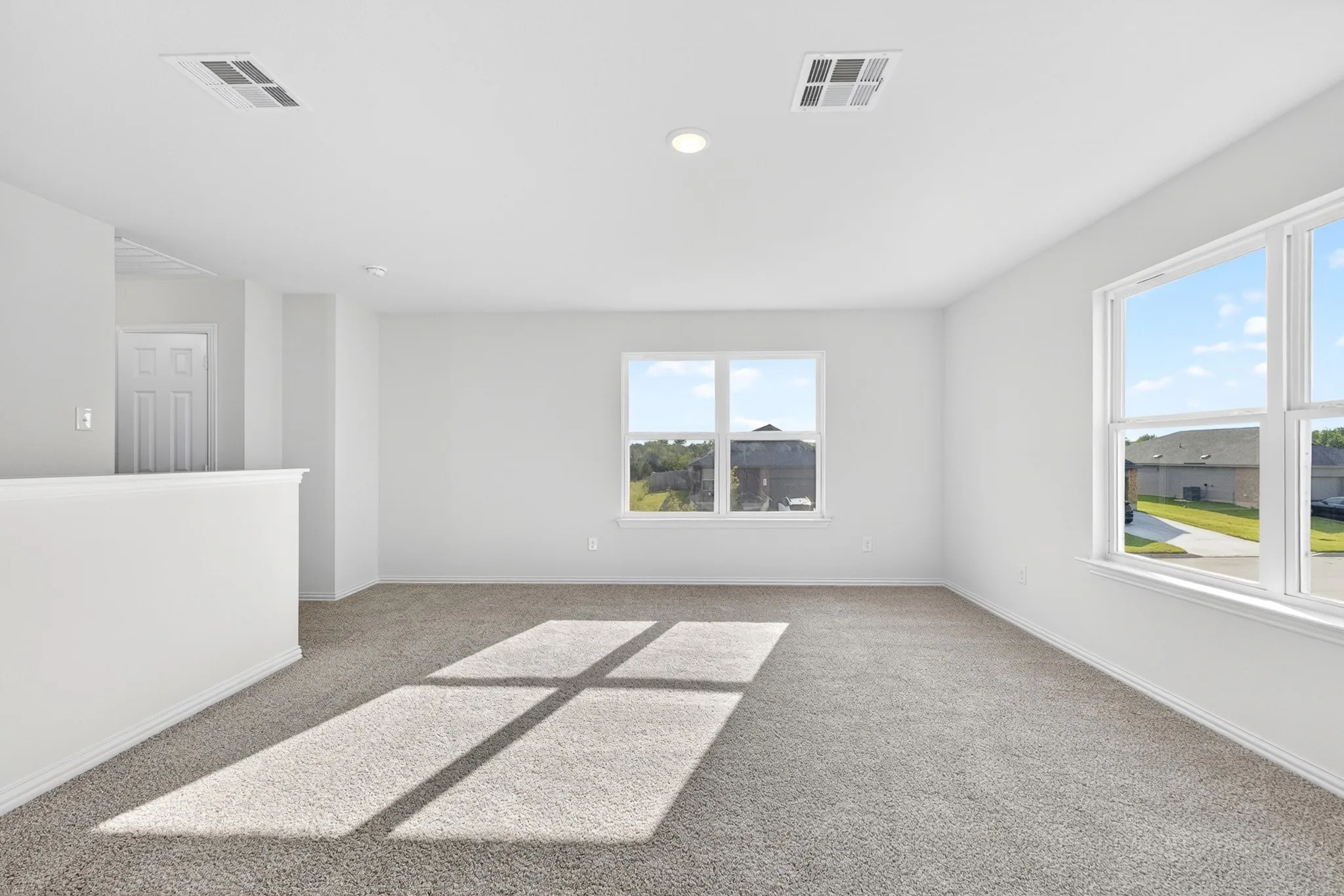 Carpeted flooring, recessed lighting, and multiple windows