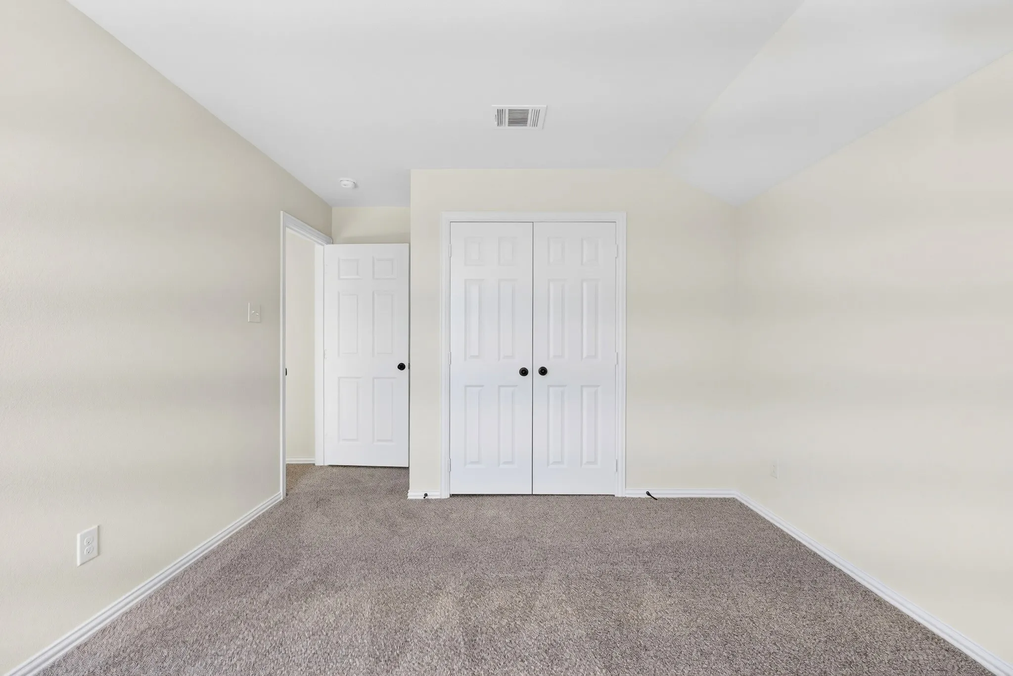Neutral-toned walls complement the gray carpeting
