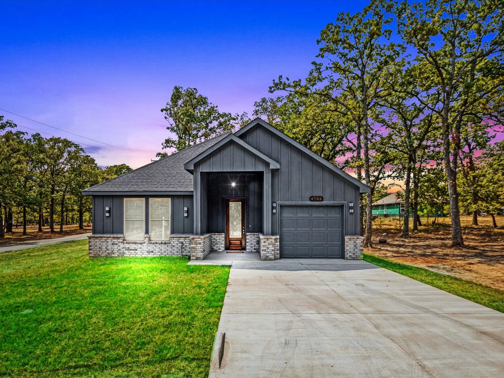 Contemporary exterior with vertical panel siding and a brick-and-stone facade