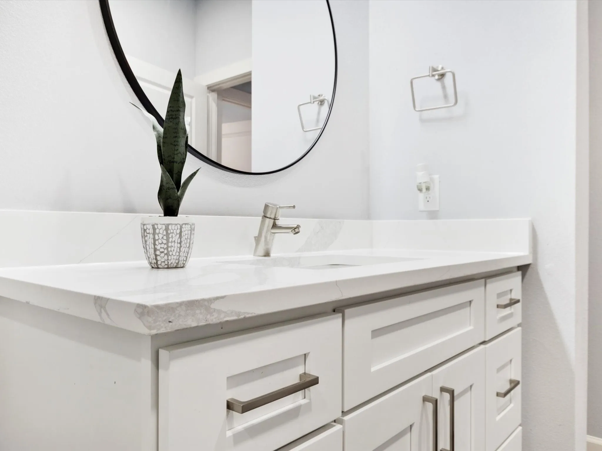 White shaker-style vanity with multiple drawers and cabinet storage