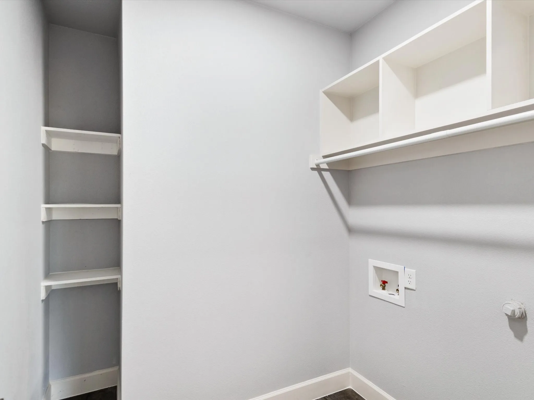 Built-in shelving, wall-mounted clothes rod, and appliance hookups
