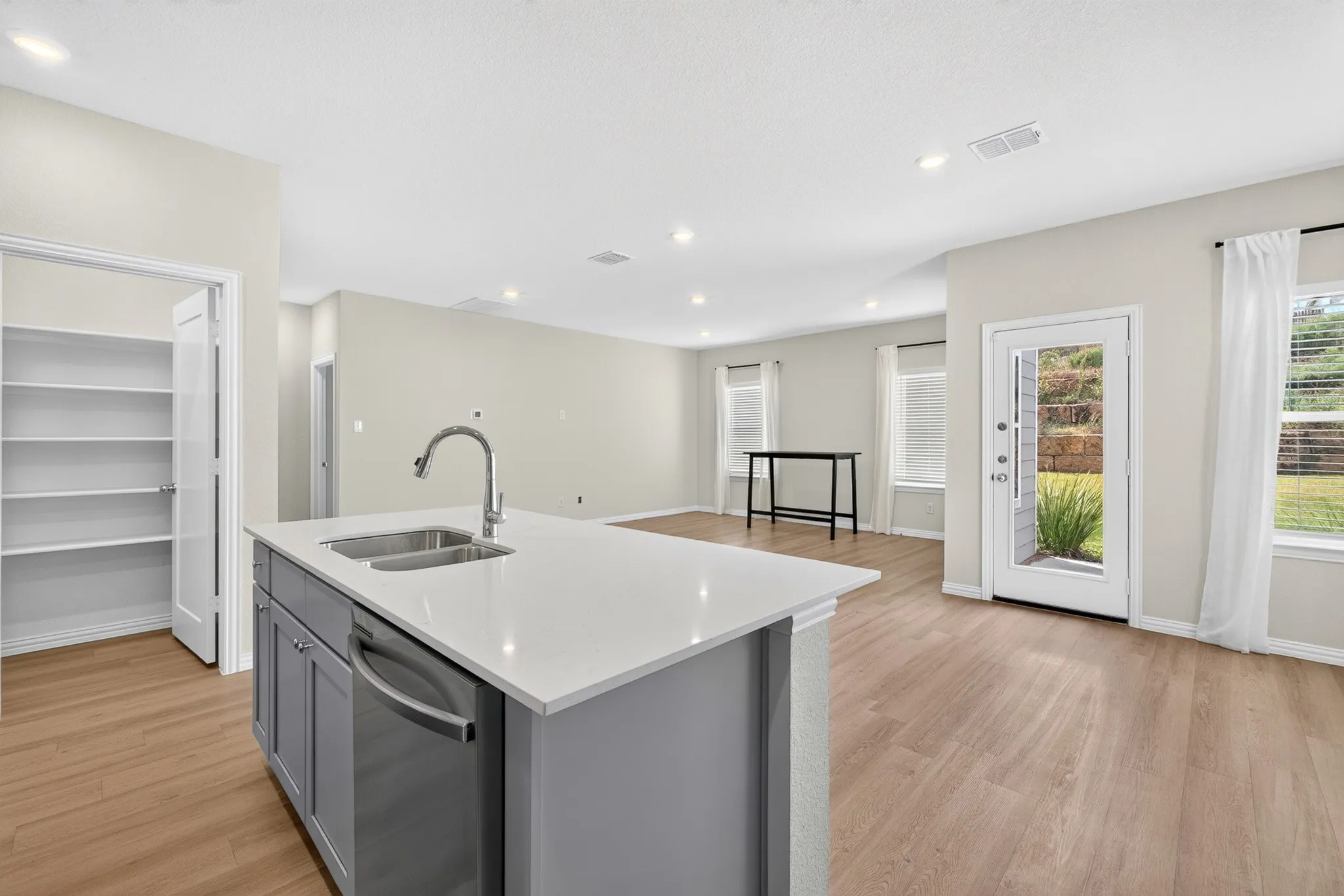 Kitchen island with a dual-basin stainless steel sink, gooseneck faucet, and integrated dishwasher