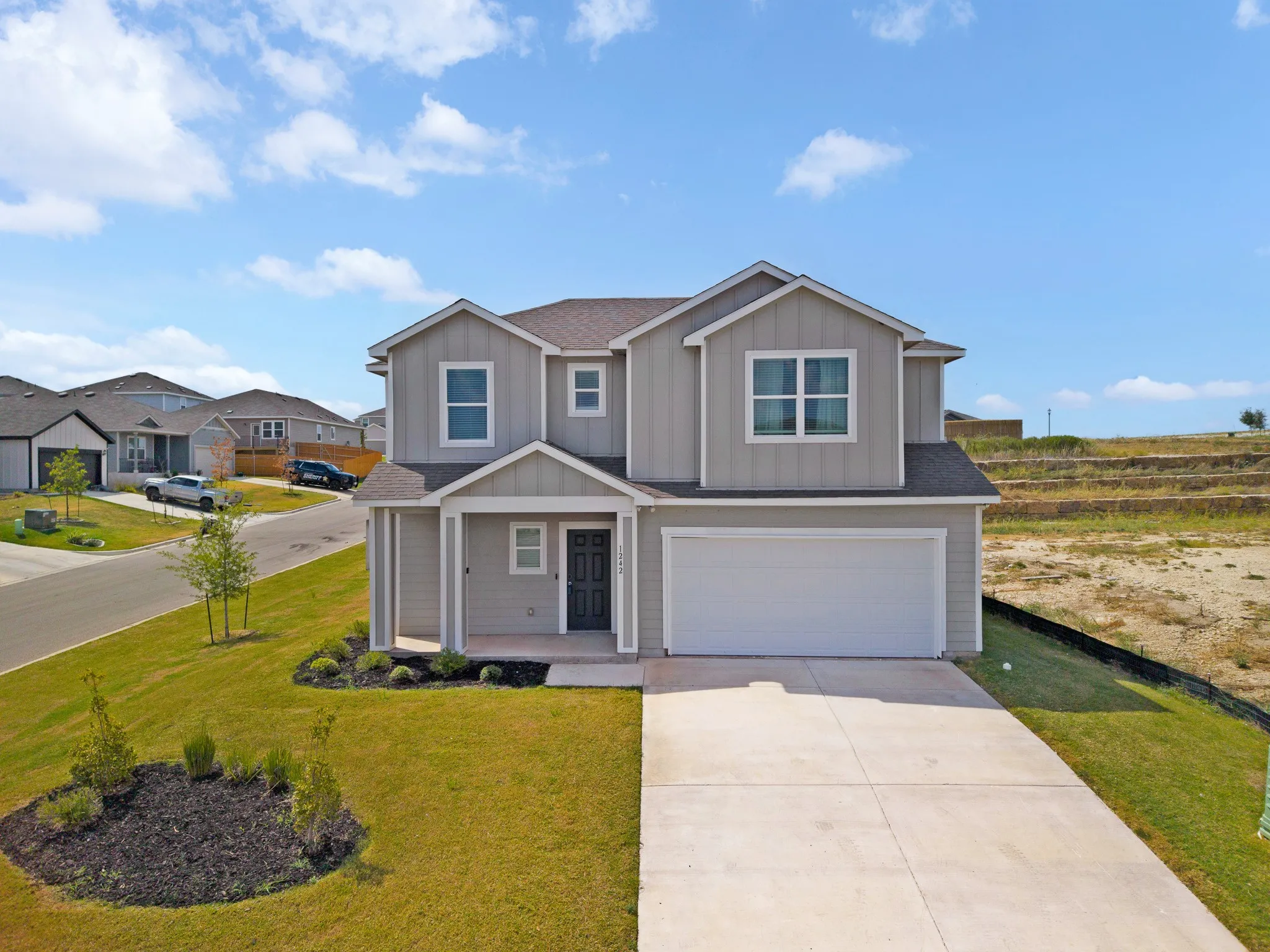 Two-story residence featuring light gray siding with white trim accents