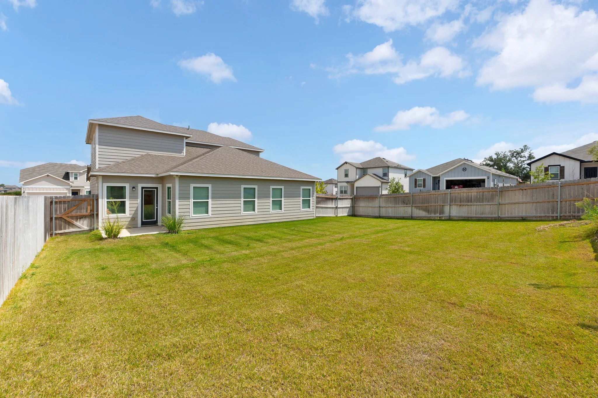 Expansive rear yard featuring green lawn