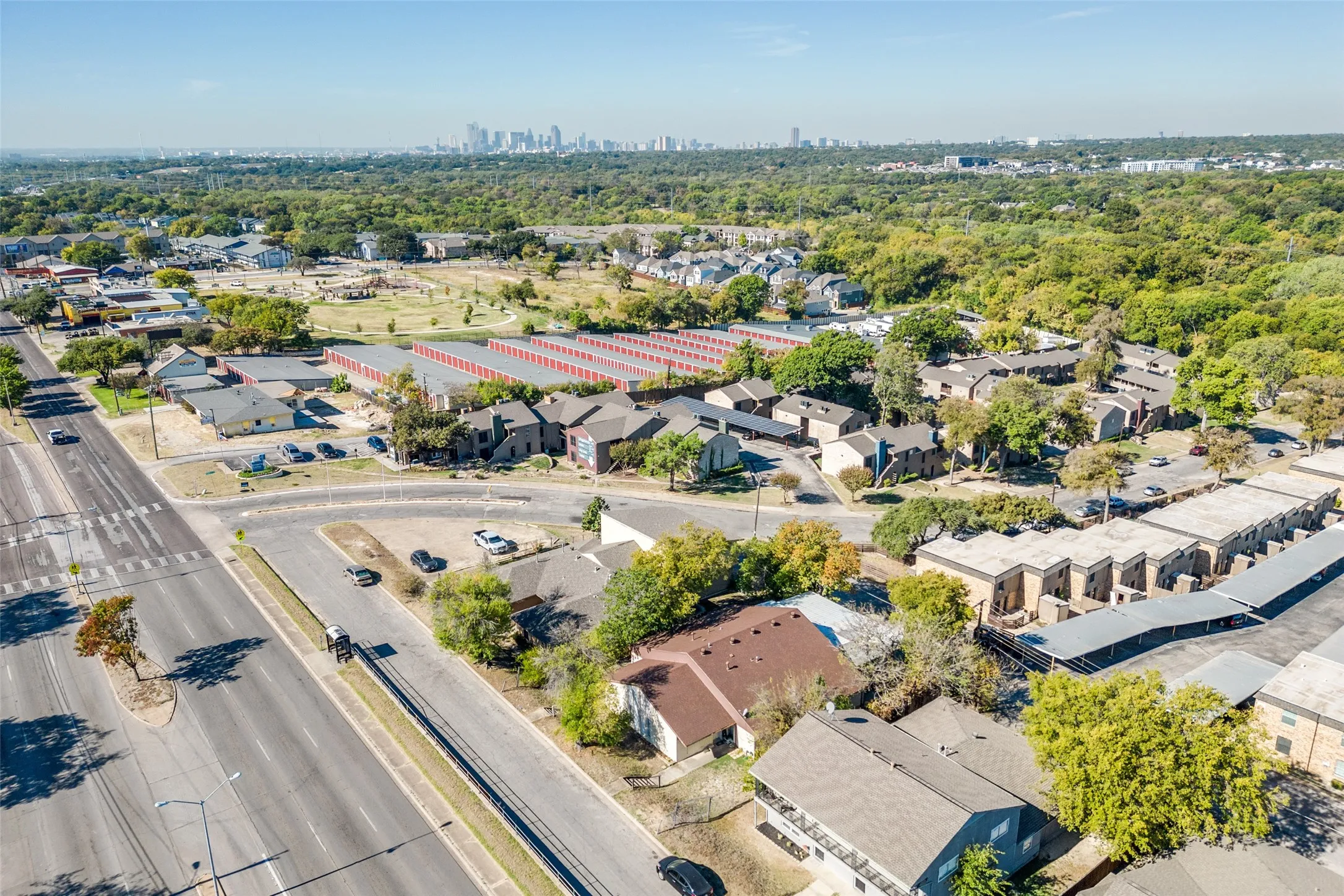 Expansive tree-lined neighborhood with a distant cityscape