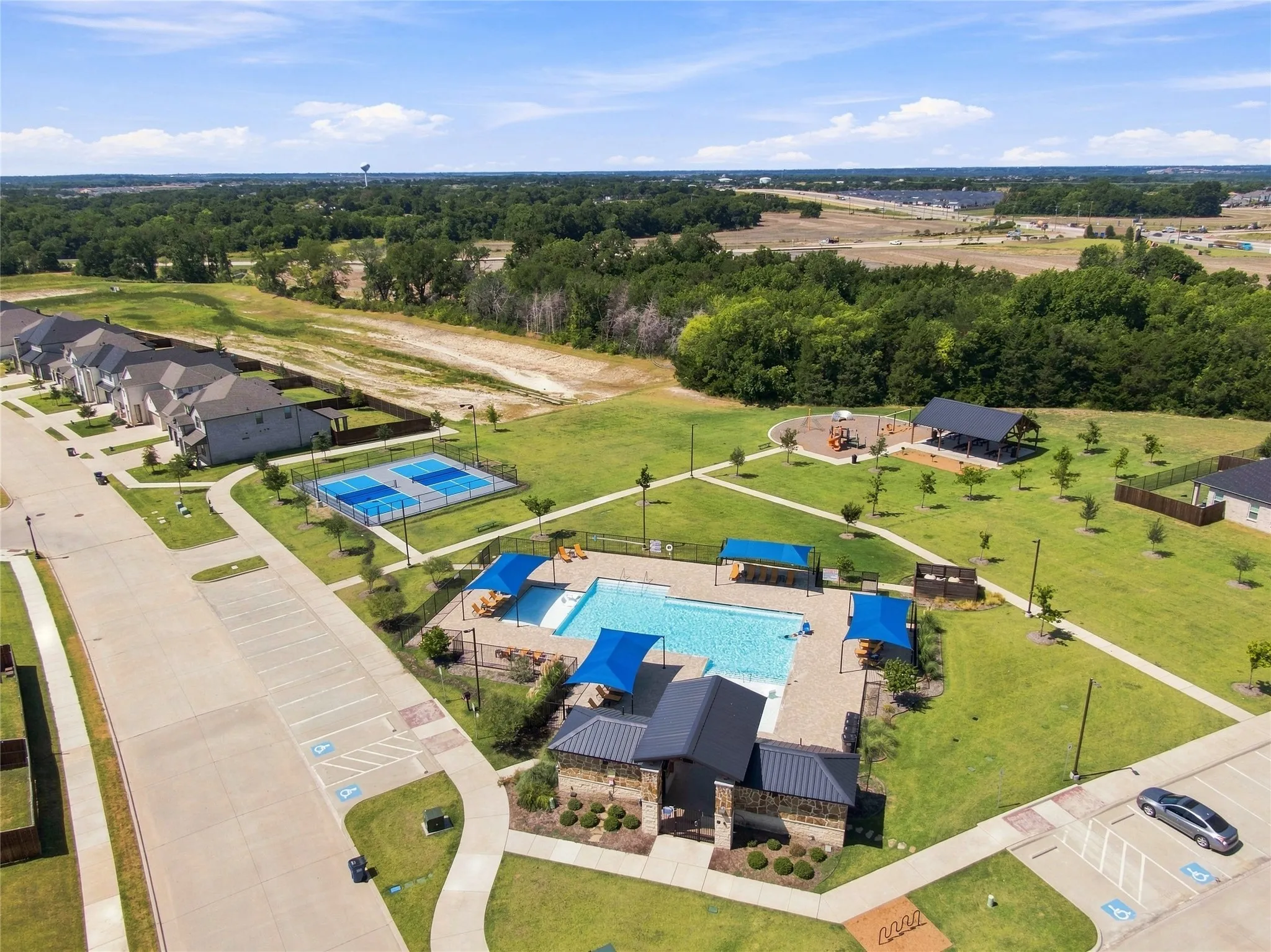 Community amenities featuring a swimming pool, covered lounging areas, sports courts, a playground, and a covered pavilion