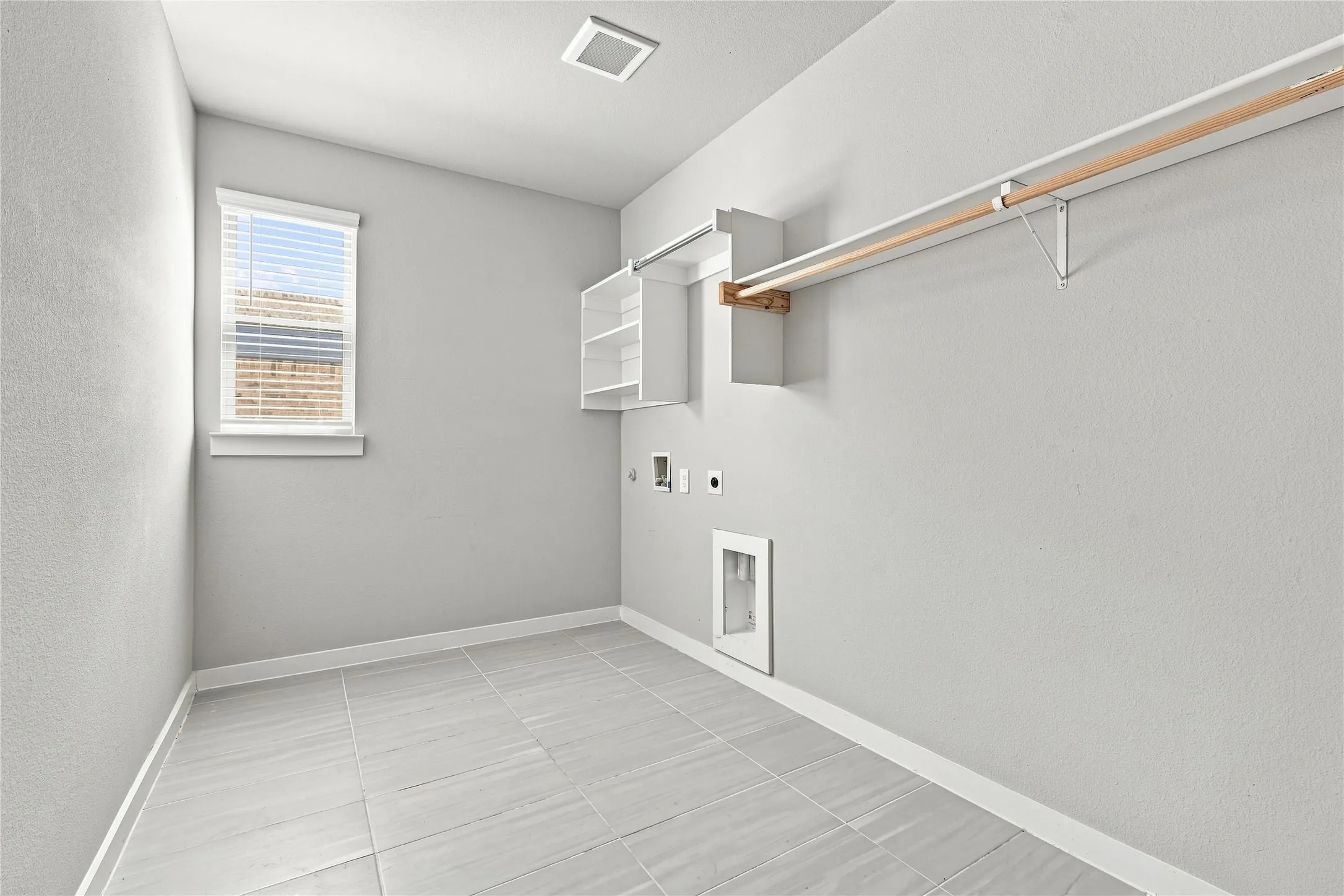 Tile flooring, built-in shelving, hanging rod, window with blinds, and recessed lighting