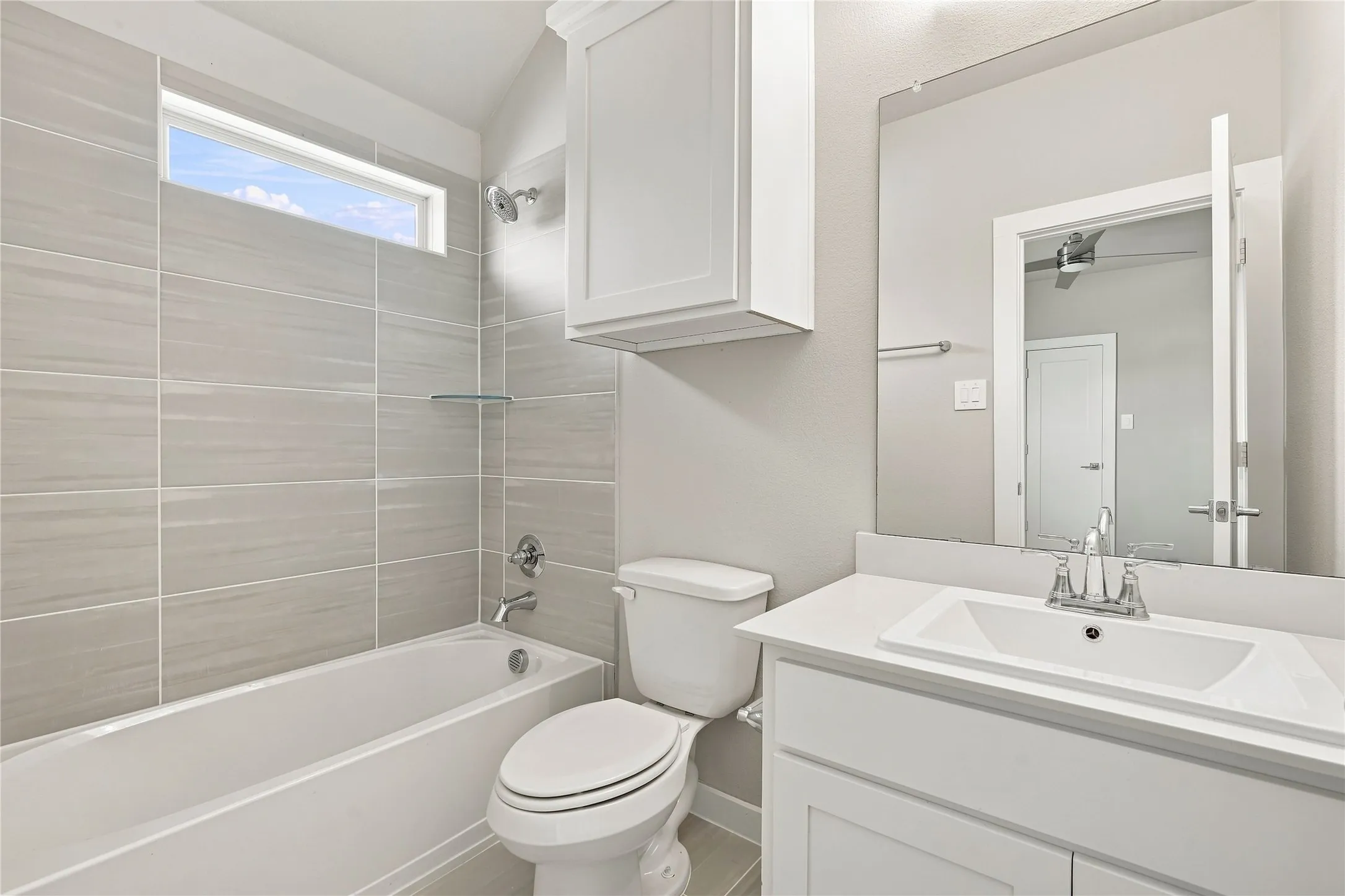 White vanity with a built-in rectangular sink, chrome-finish faucet, and a large wall-mounted mirror
