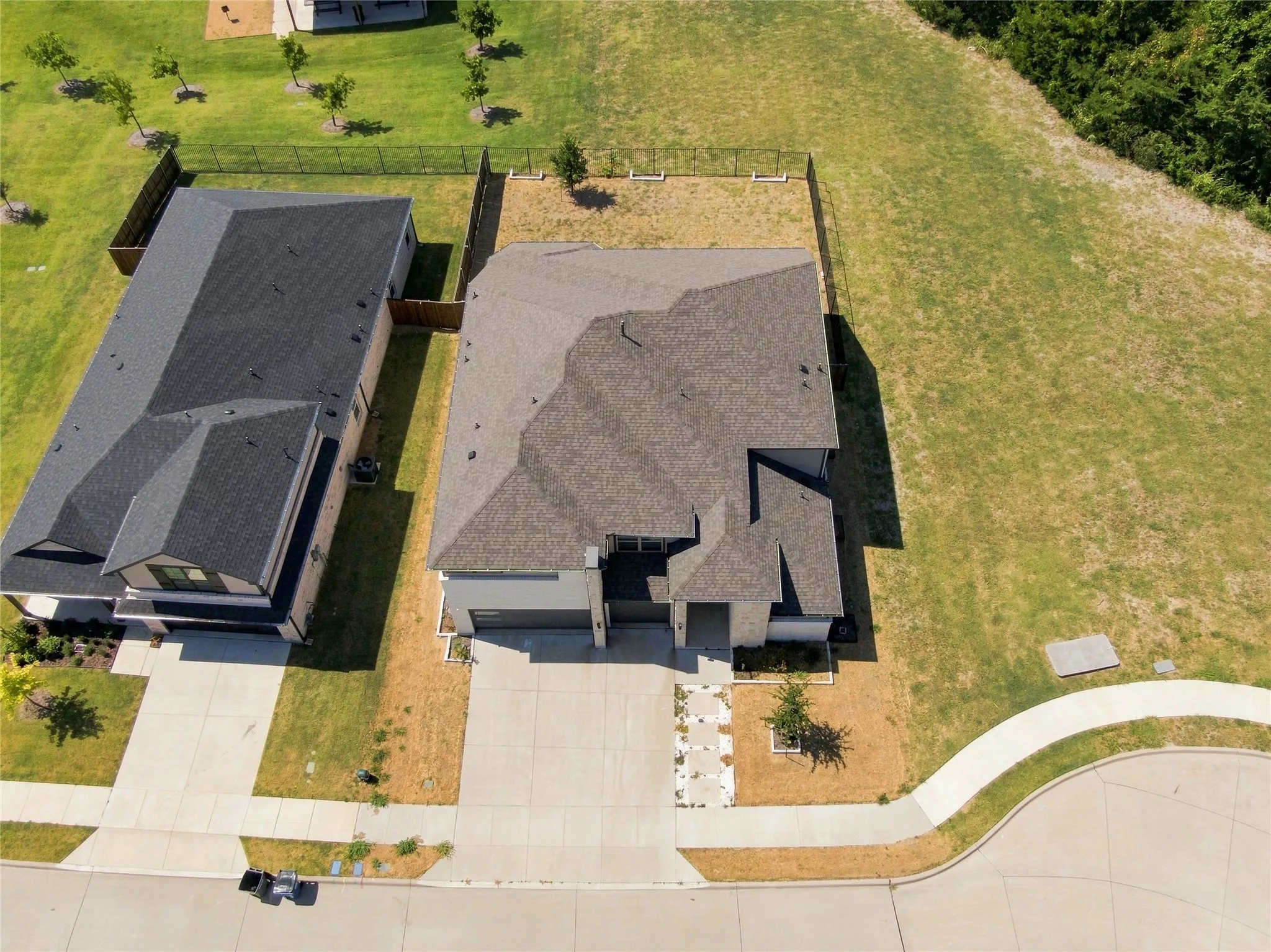 Contemporary residential property with a multi-gabled dark shingle roof, attached garage, and a concrete driveway