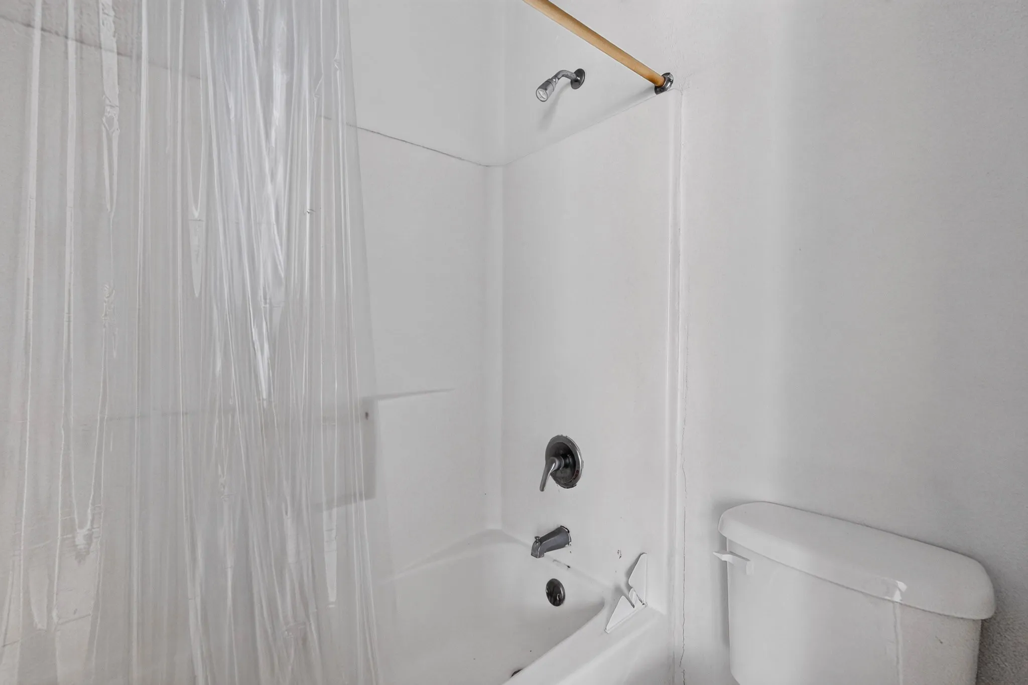 Tub-shower combination with dark-finish fixtures and a shower rod