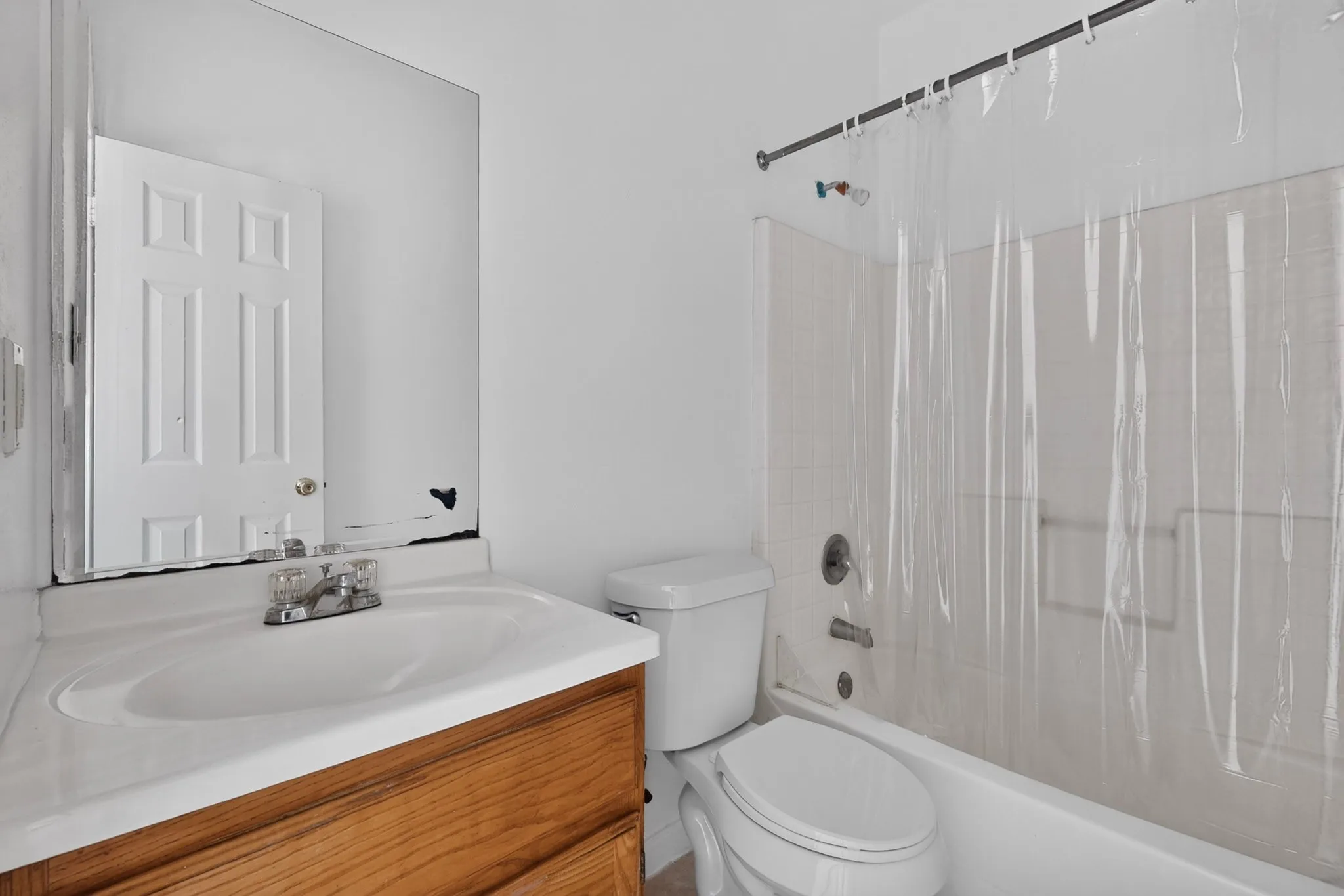 Vanity with wood-finish cabinetry, integrated sink, and wall-mounted mirror