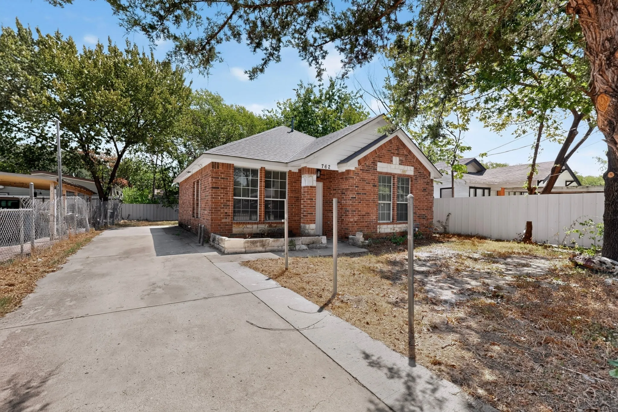 Brick exterior with a gabled roof and a concrete driveway