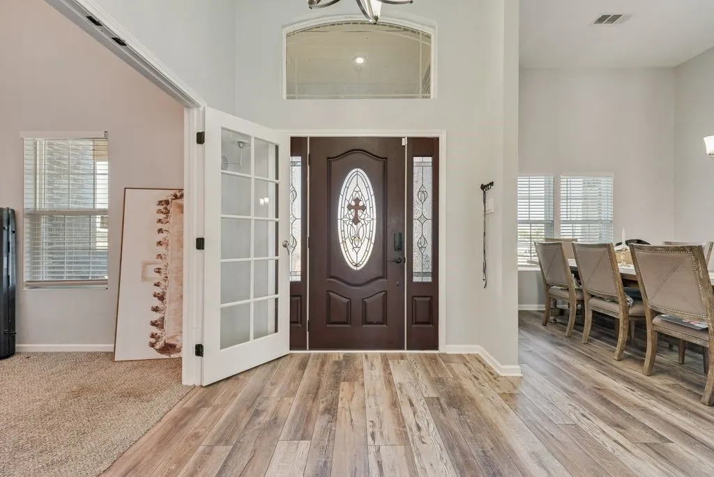 Grand entry with wood-finish flooring, a decorative glass front door, and a transom window