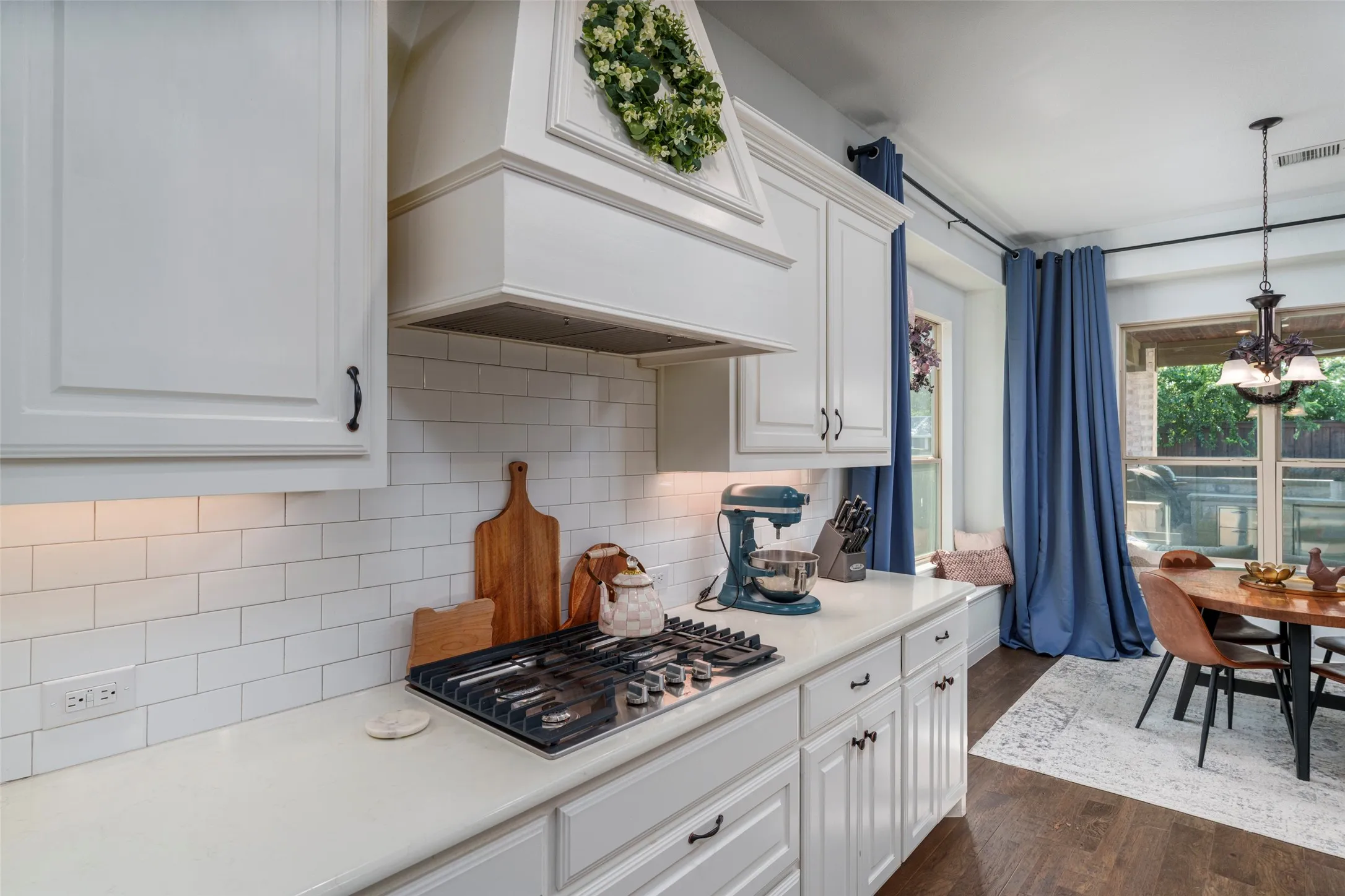 Tons of storage and counter space in this kitchen featuring the gas cooktop and beautiful vent hood.