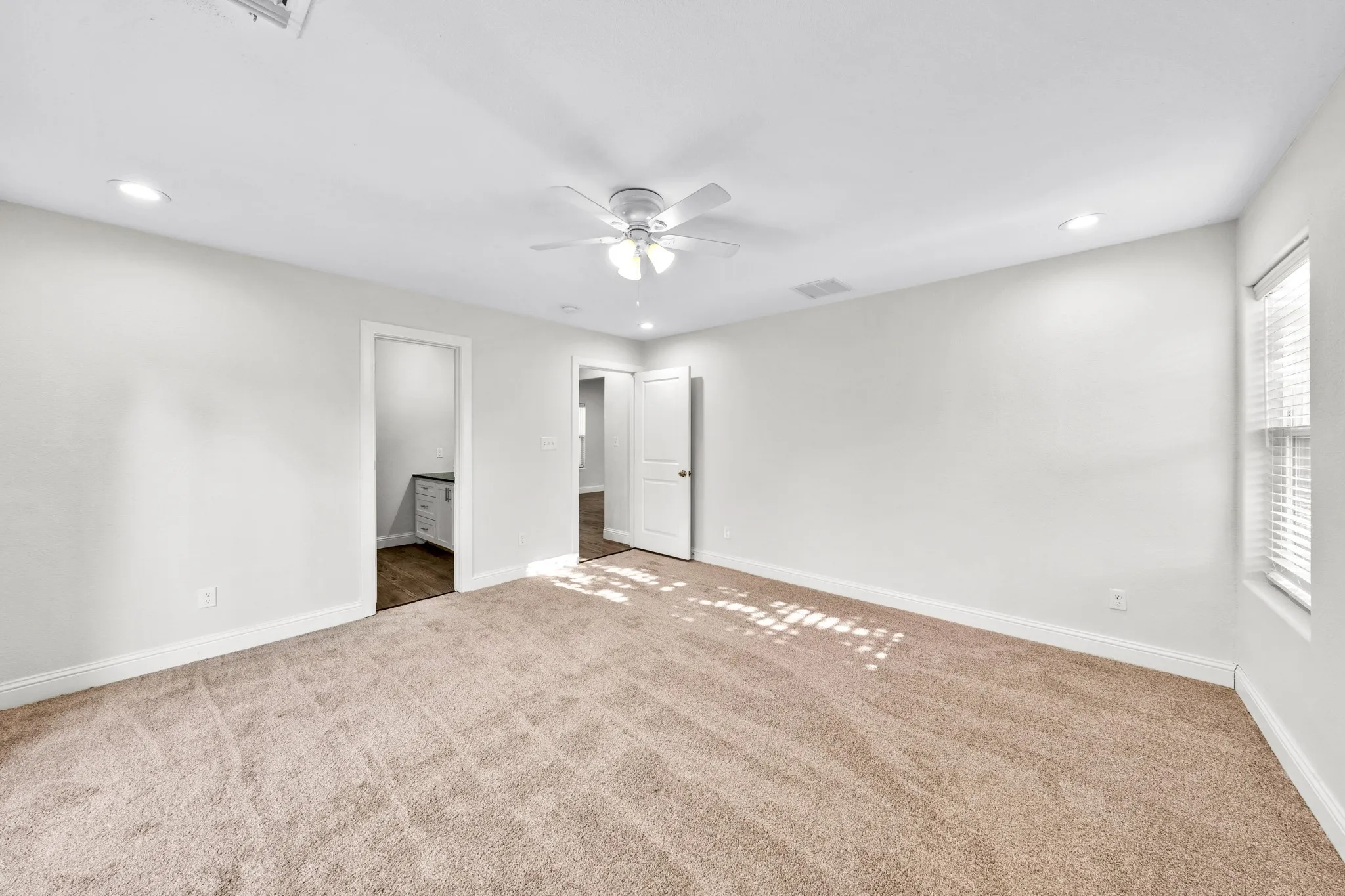 Spacious interior with carpet flooring, recessed lighting, and a ceiling fan