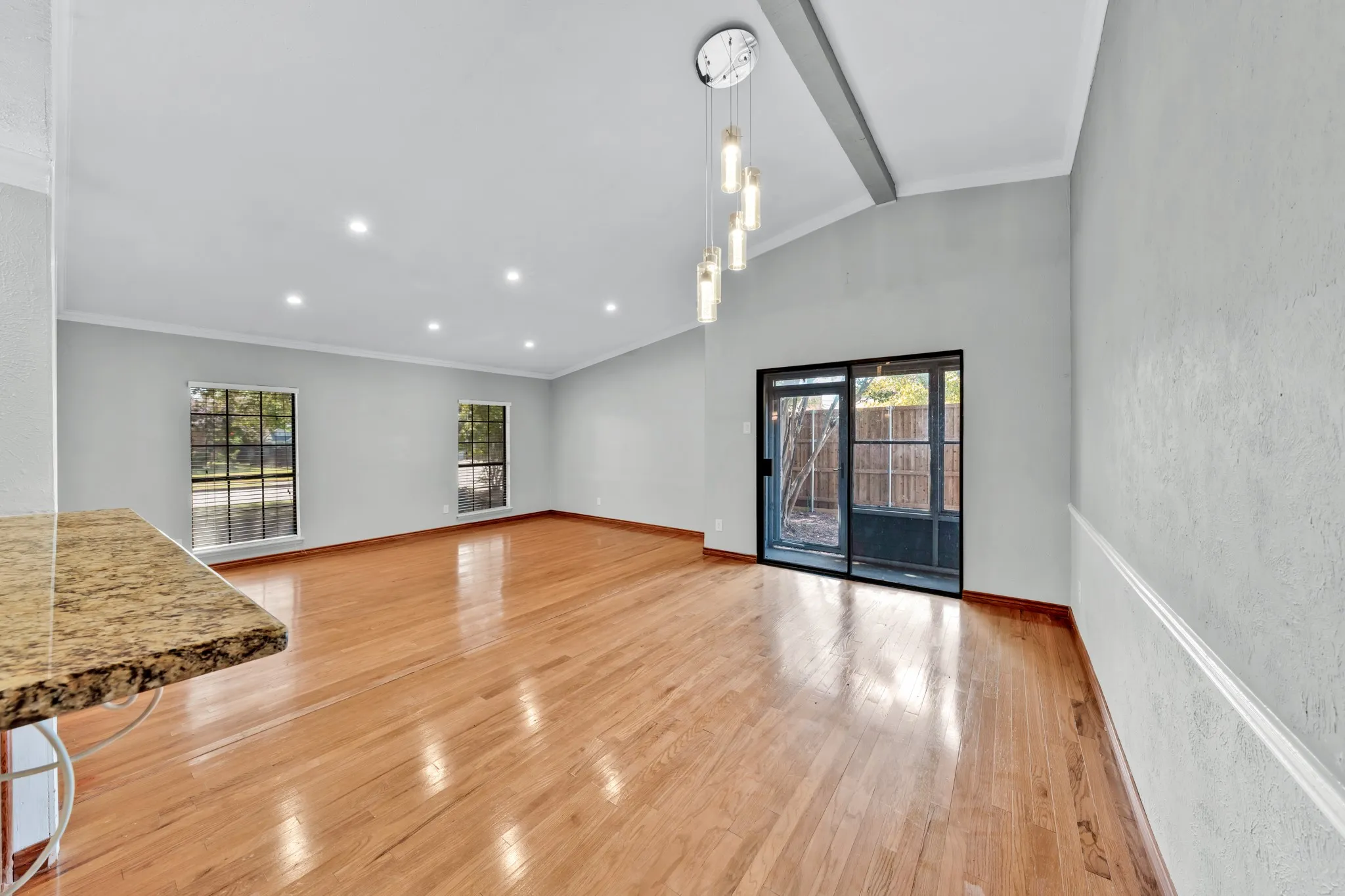 Wood-finish flooring throughout, recessed lighting, and a modern chandelier