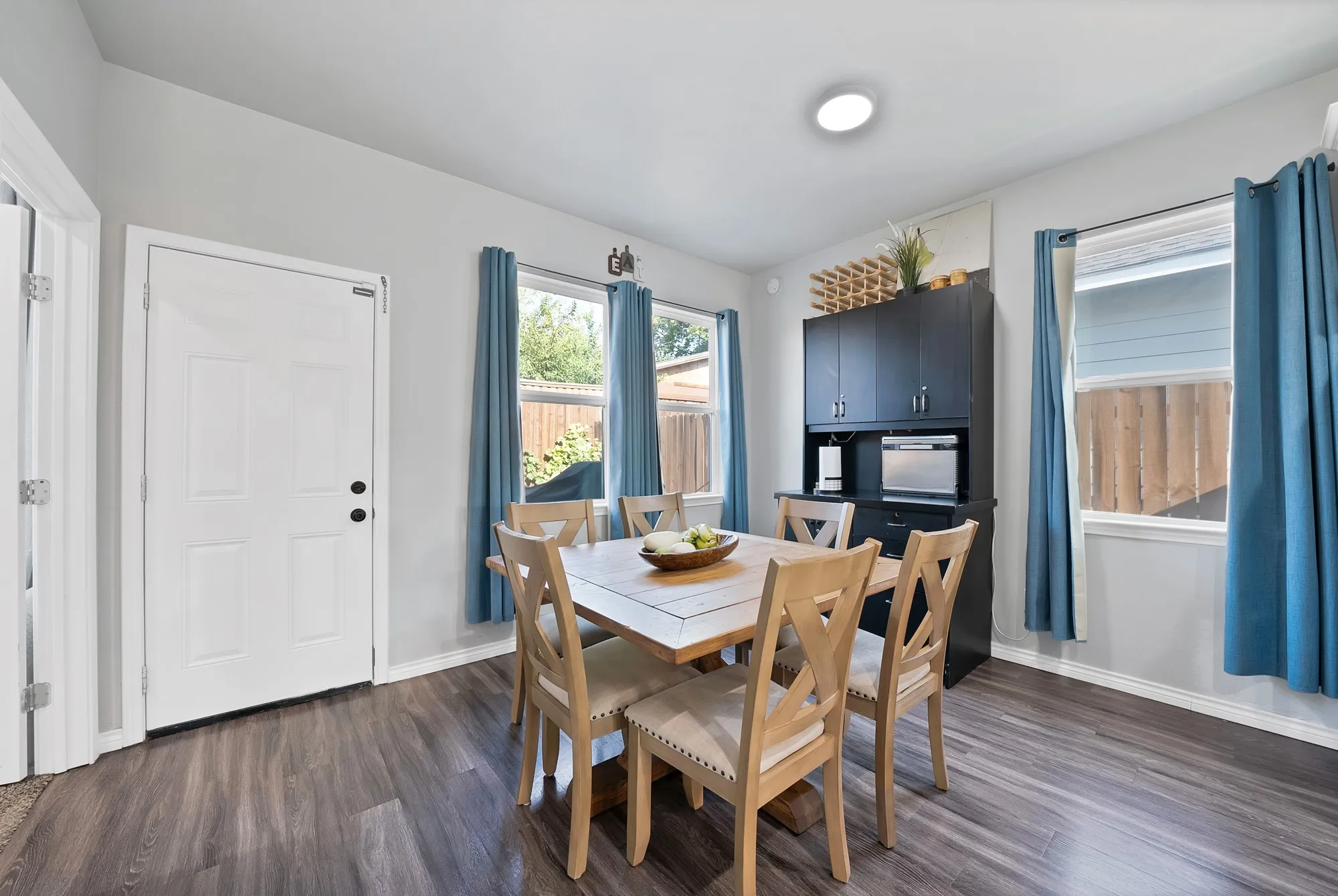 Spacious dining area featuring wood-finish flooring, multiple windows, recessed lighting, and a built-in storage​​‌​​​​‌​​‌‌​‌‌​​​‌‌​‌​‌​‌​​​‌​​ cabinet