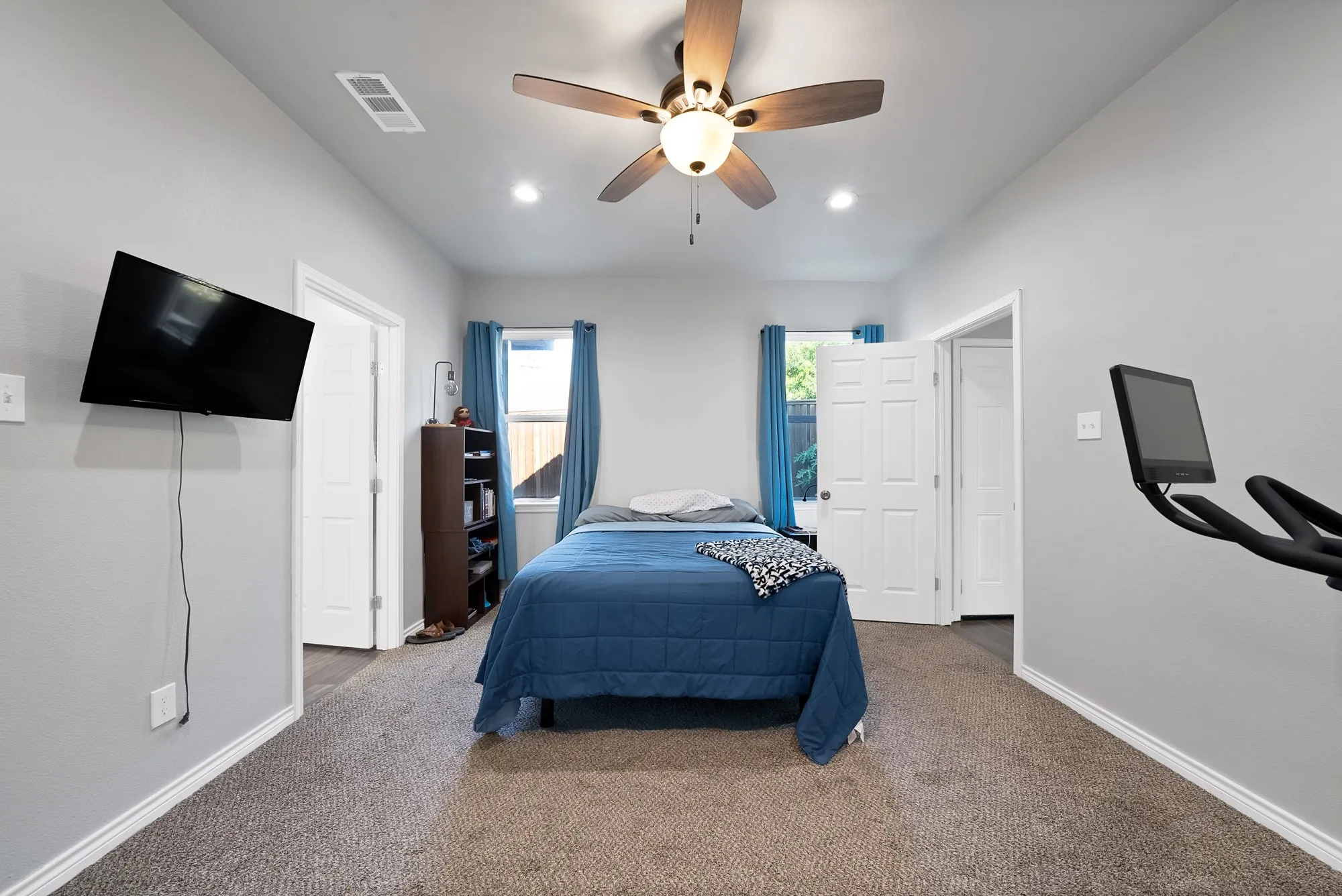 Carpeted room featuring a ceiling fan with integrated lighting, recessed lighting, and white paneled doors