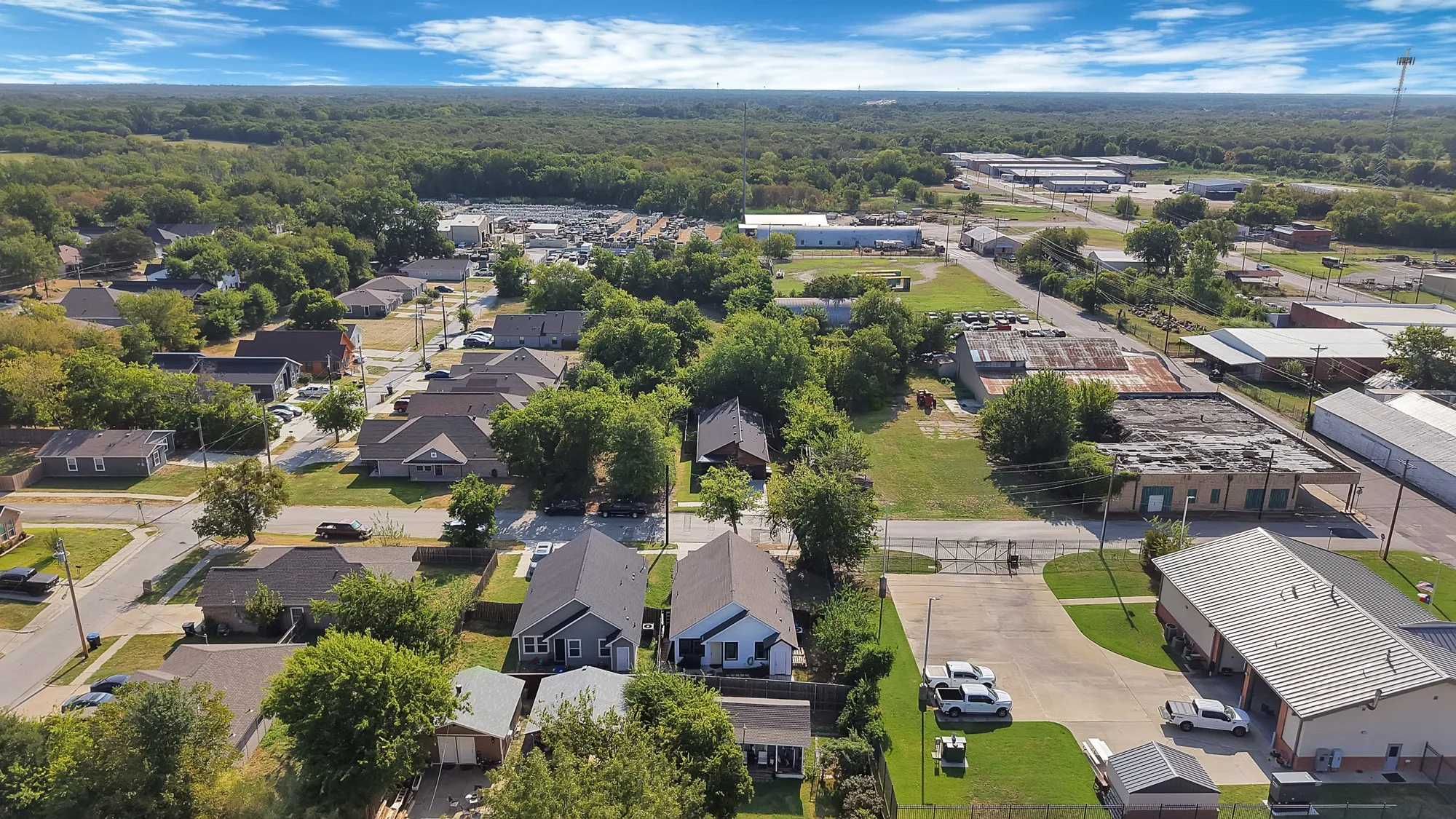 Residential neighborhood setting with established trees and surrounding commercial properties