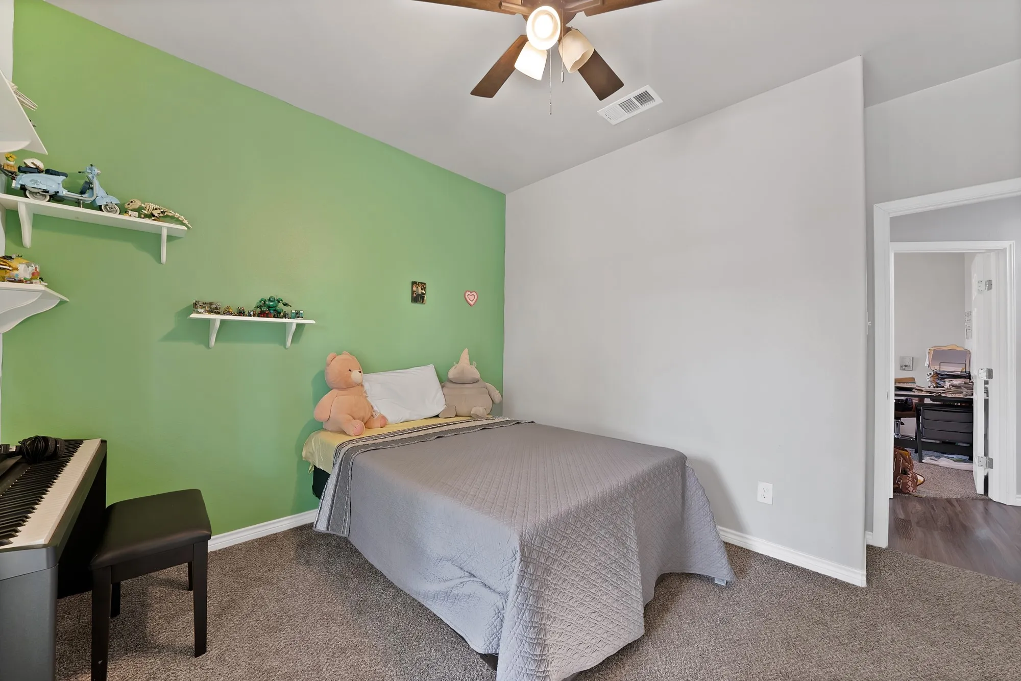 Carpeted room with a ceiling fan, sloped ceiling, and built-in wall shelving