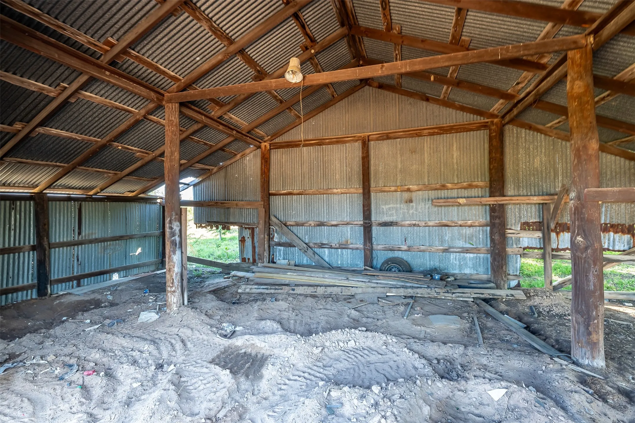 Corrugated metal roof, exposed wood beam construction, corrugated metal wall panels