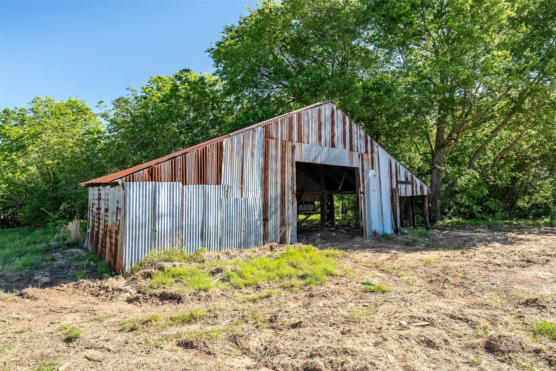 Corrugated metal-sided structure with an open-front design and sloped roof