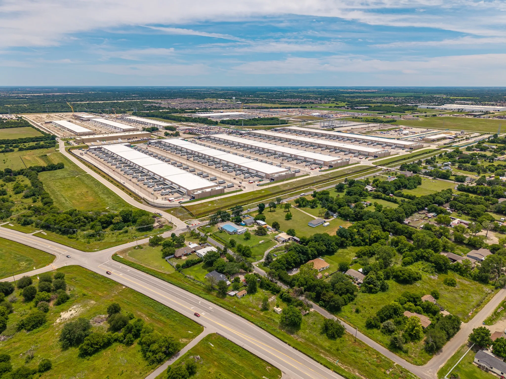 Expansive industrial complex featuring multiple large-scale buildings with extensive rooftops and surrounding paved areas
