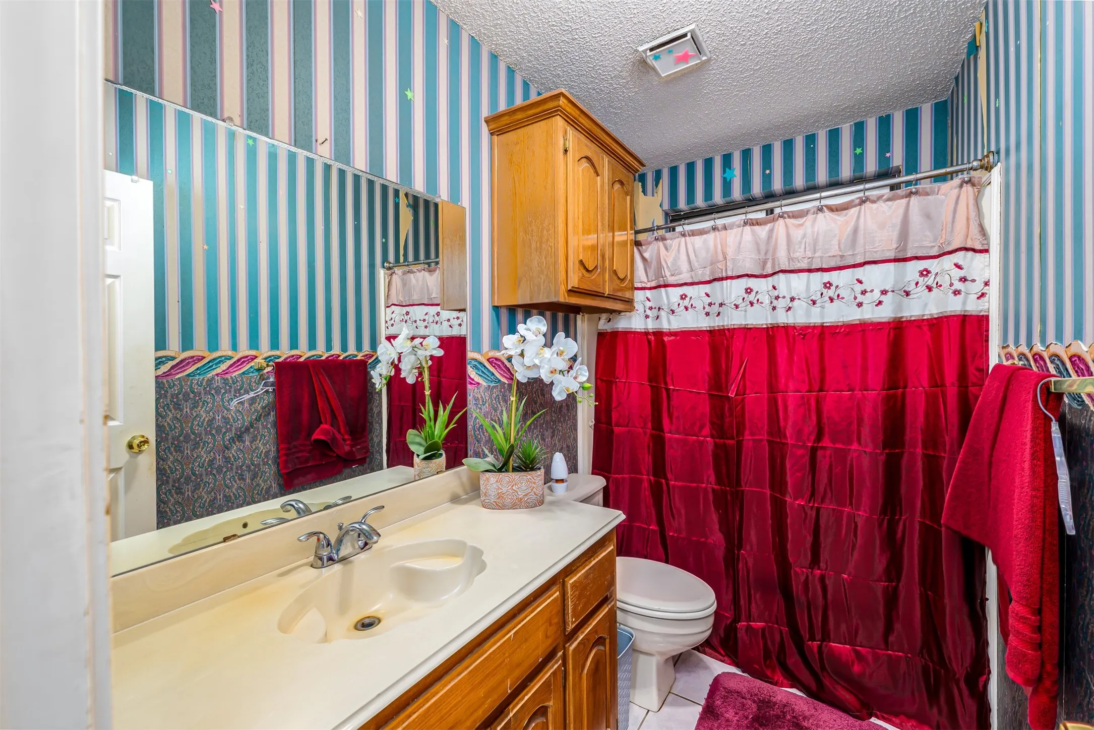 Built-in vanity with integrated sink, chrome faucet, wall-mounted mirror, and wood-finish cabinetry
