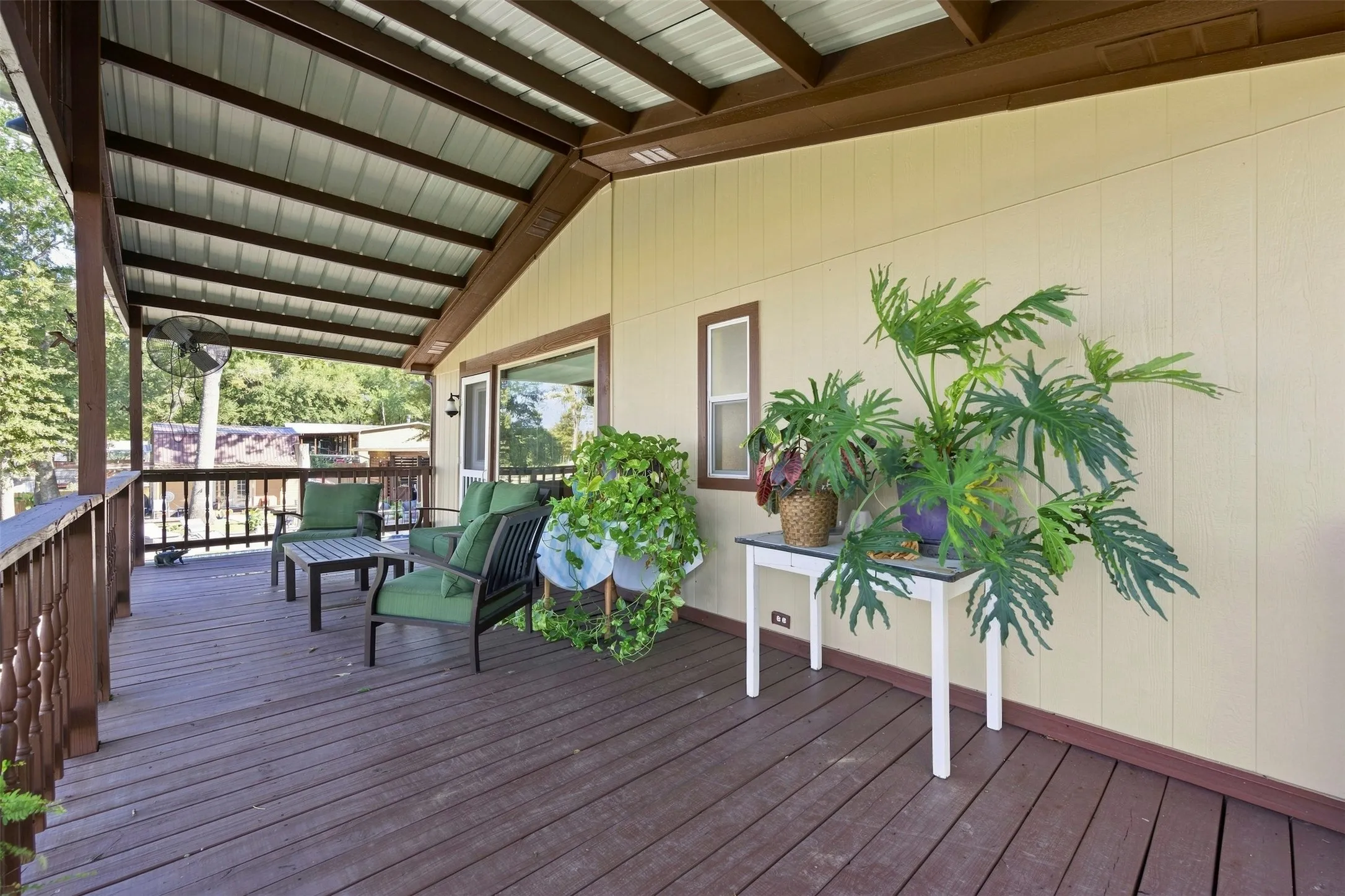 Expansive covered deck featuring wood-finish flooring, a metal roof, and a wood railing