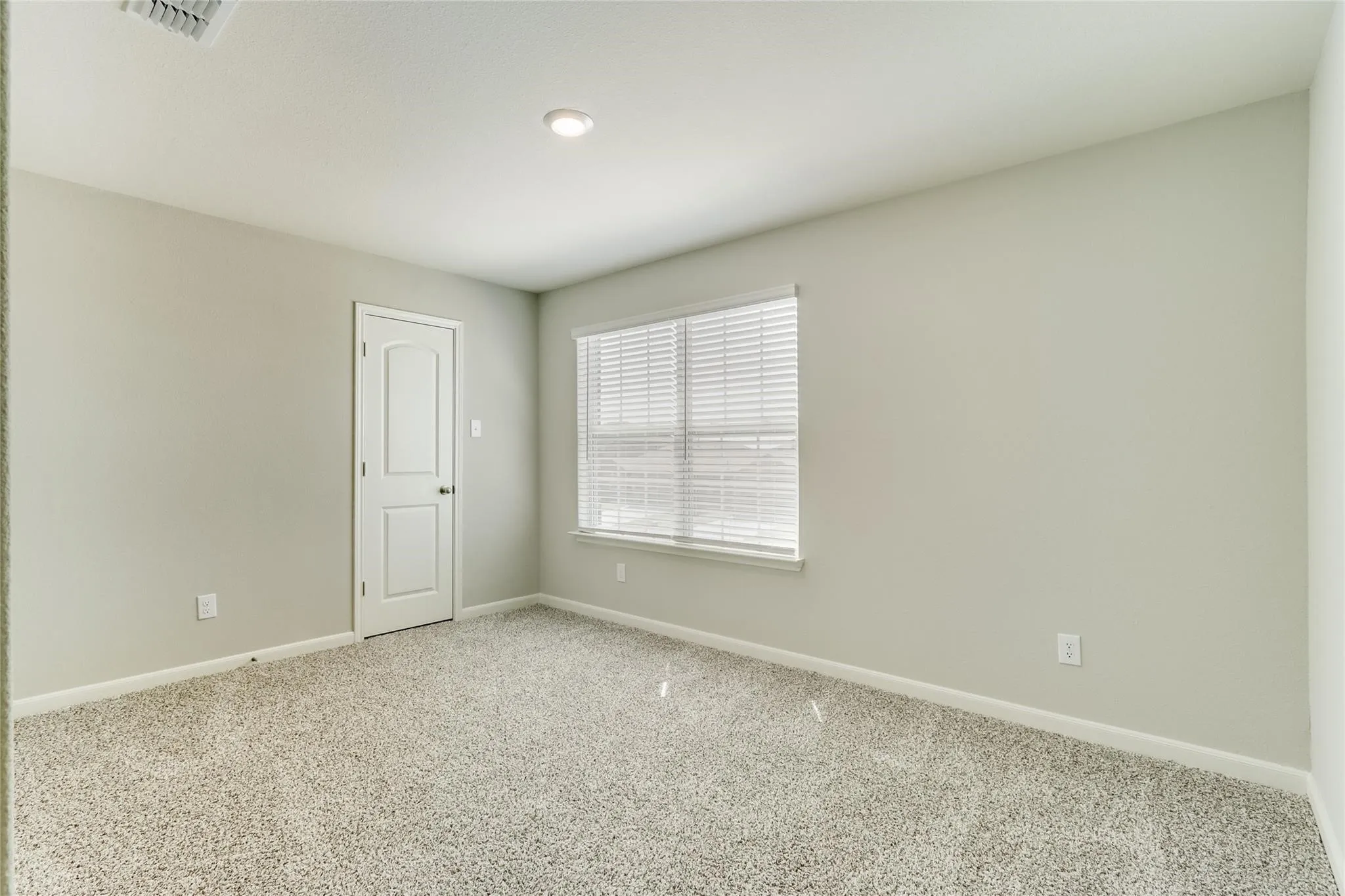 Recessed lighting, light-colored walls, window with blinds, paneled door, and carpeted flooring