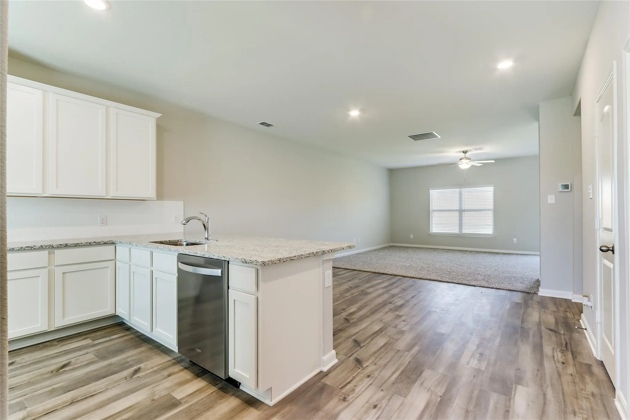 Open-concept living area with wood-finish flooring, recessed lighting, and a ceiling fan