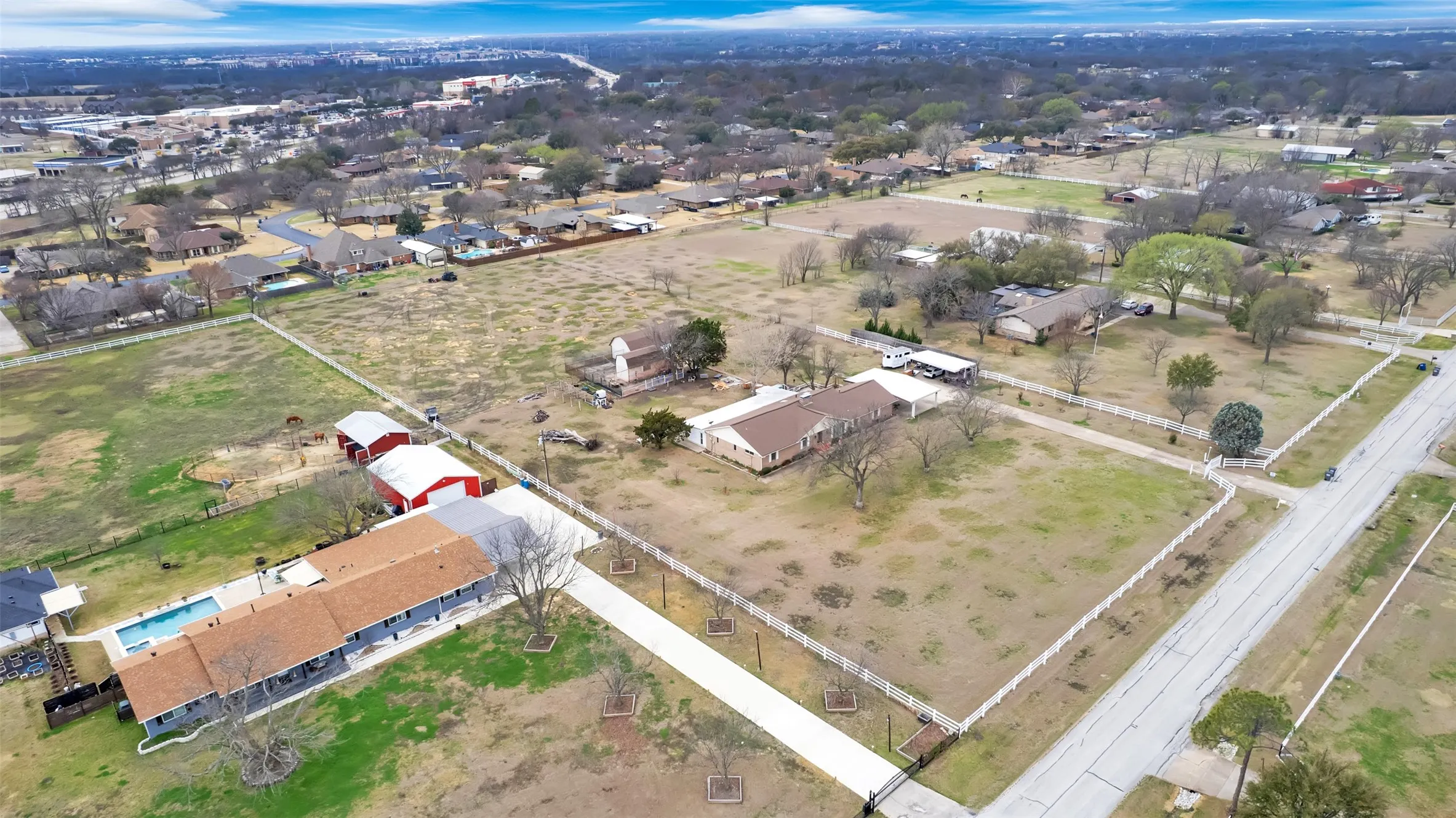 Expansive property featuring a private swimming pool, multiple outbuildings, and a perimeter fence