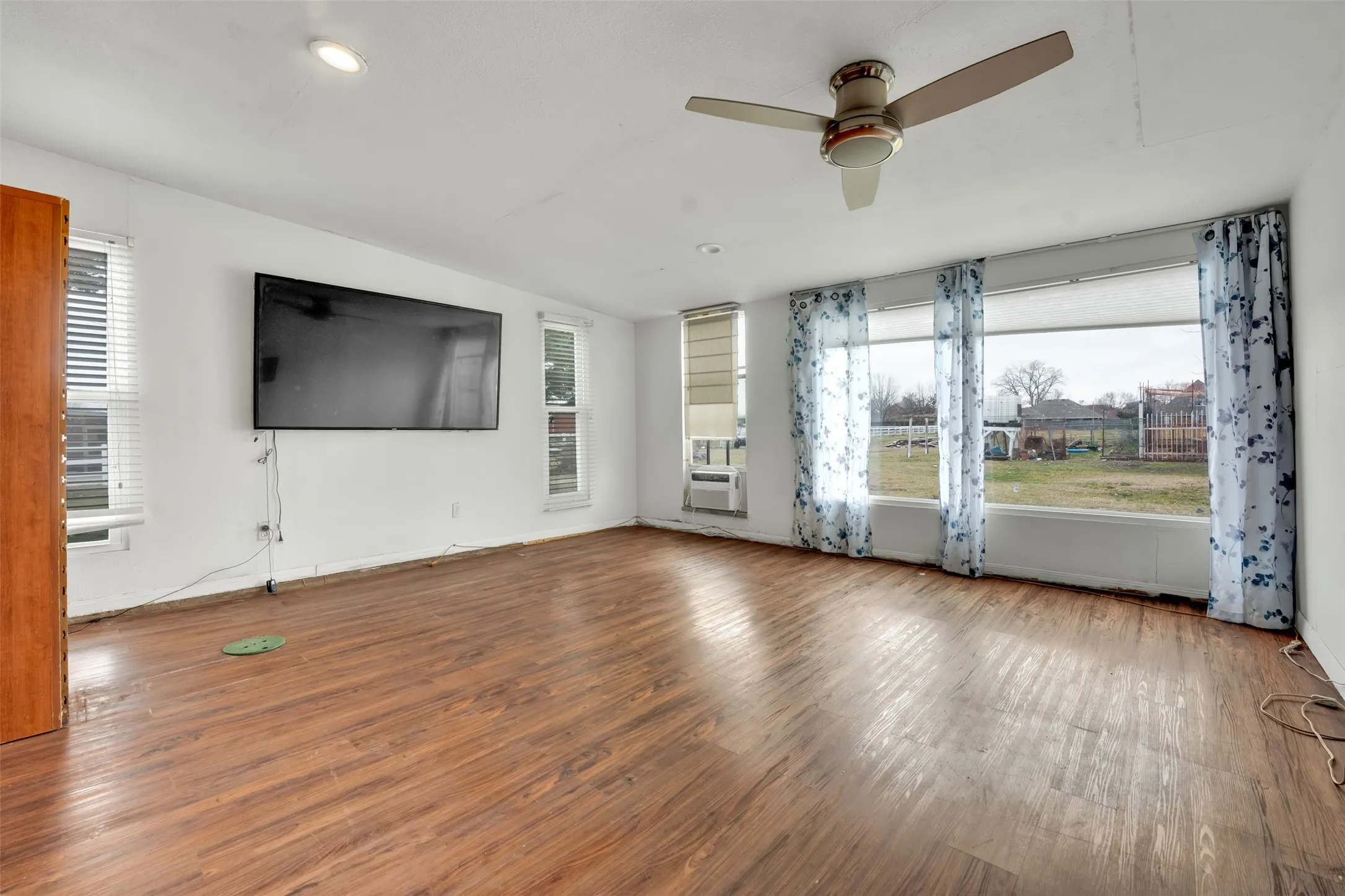 Wood-finish flooring throughout, complemented by a ceiling fan with integrated lighting