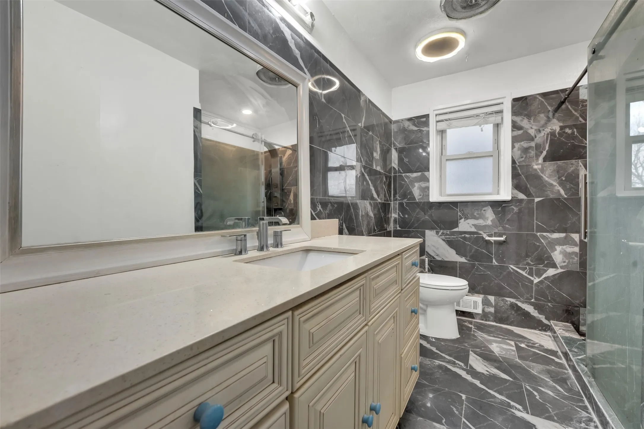 Vanity with integrated sink, rectangular mirror, and chrome fixtures