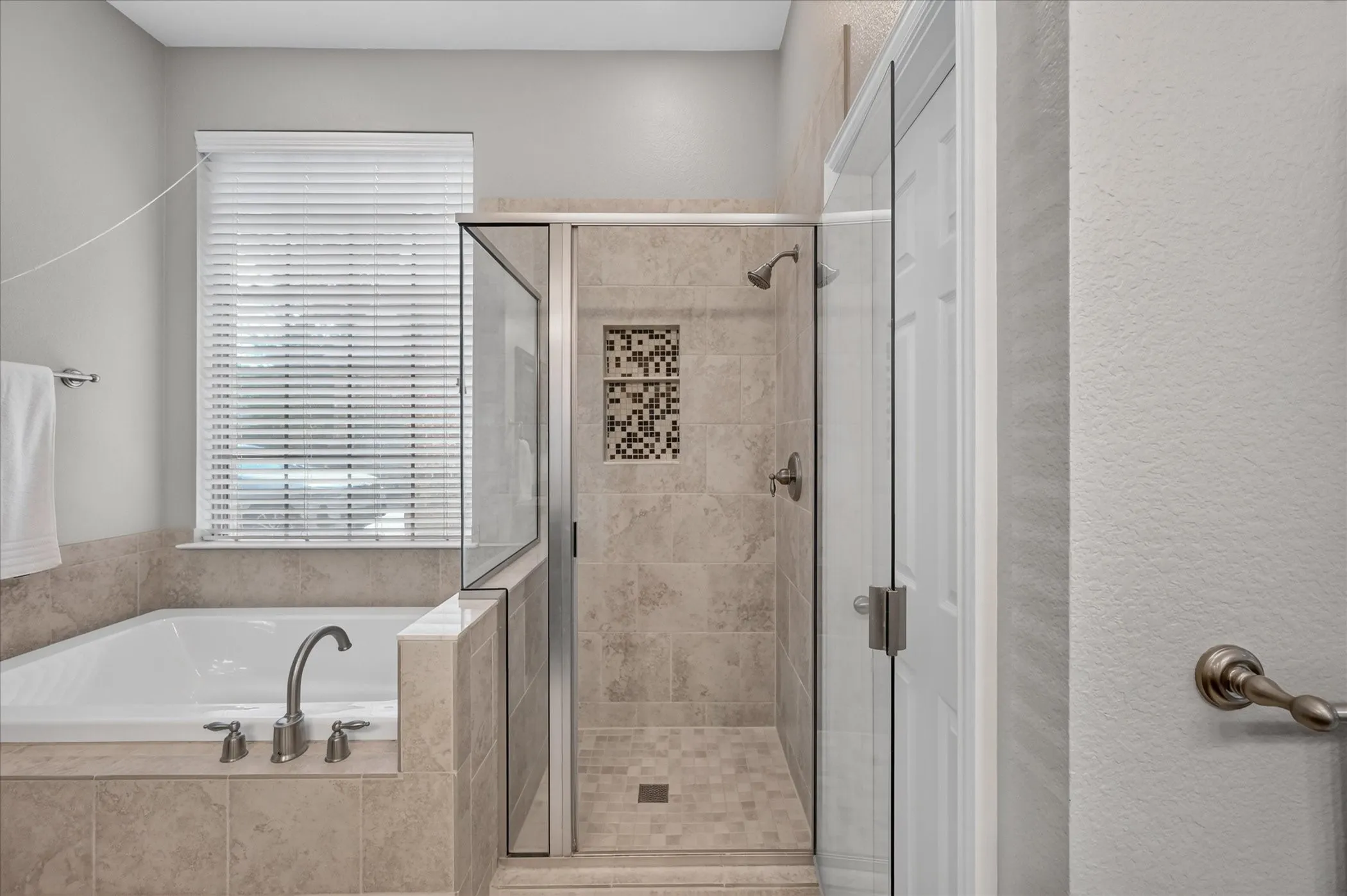 The walk-in shower in the recently renovated primary bathroom features upgraded tile