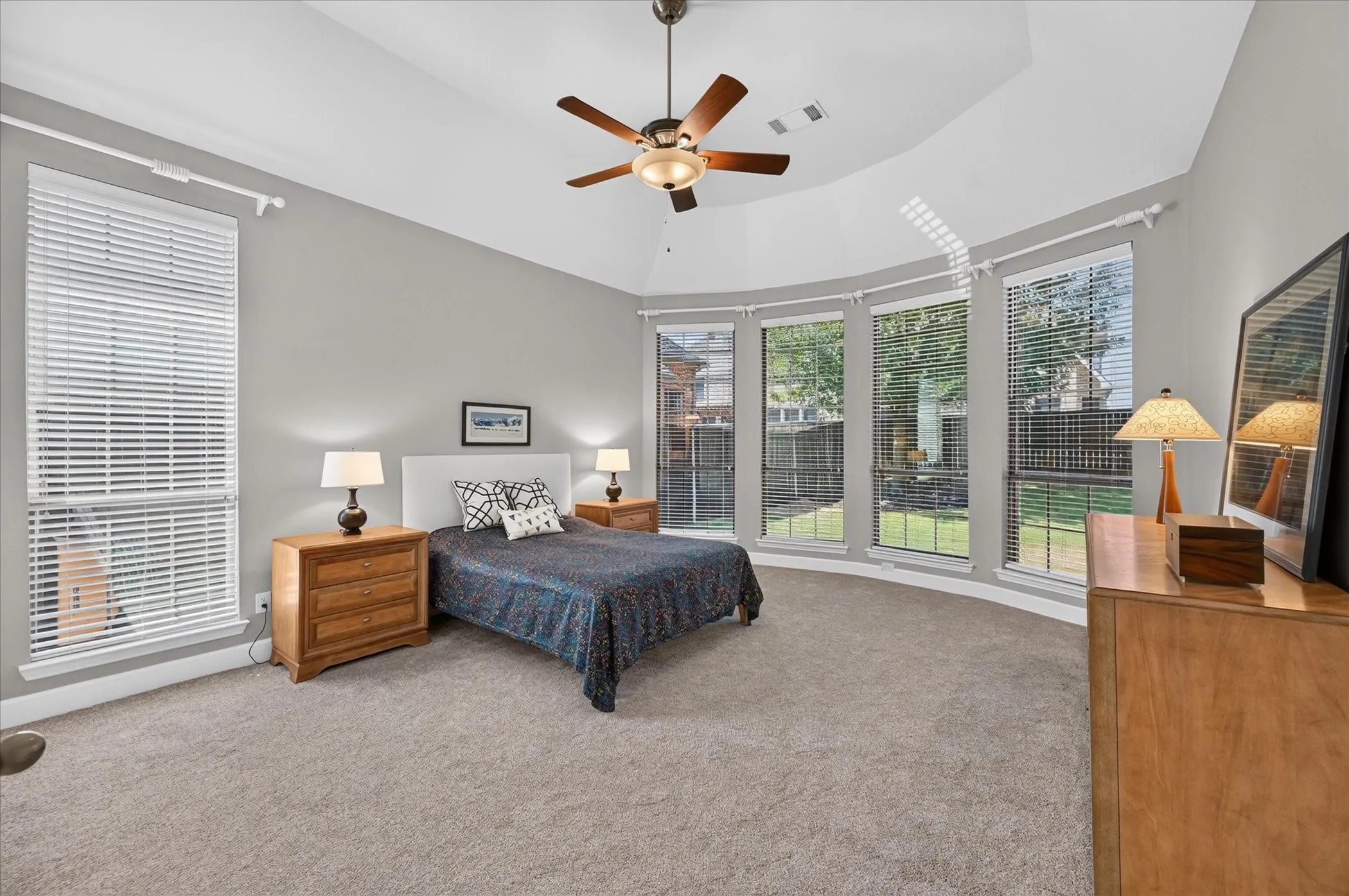 A large primary suite includes a bowed wall of windows, giving lovely views of the large back yard.
