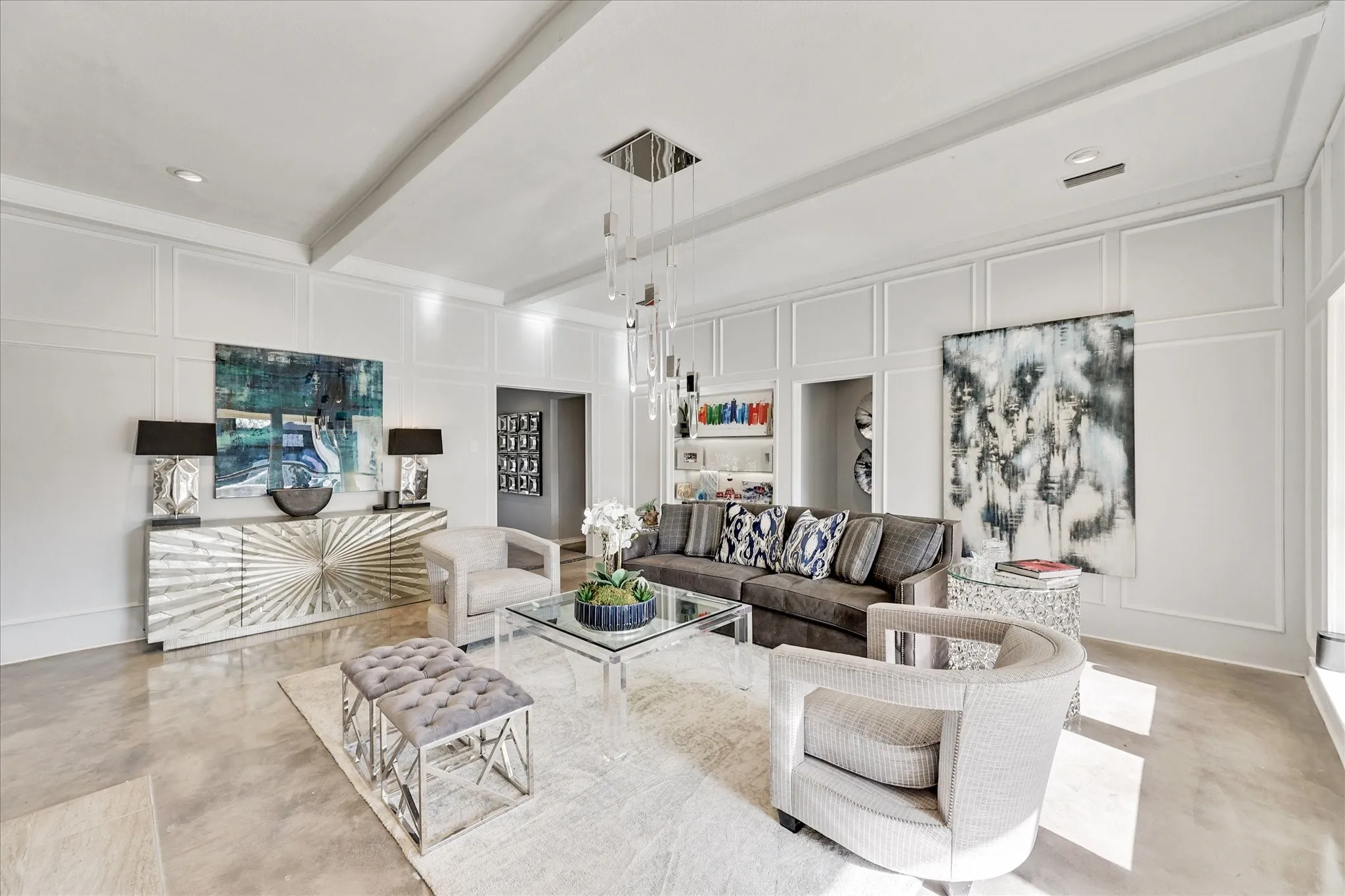 Tray ceiling with wood-finish paneling, contemporary chandelier, full-height windows, wide doorway, and polished concrete flooring