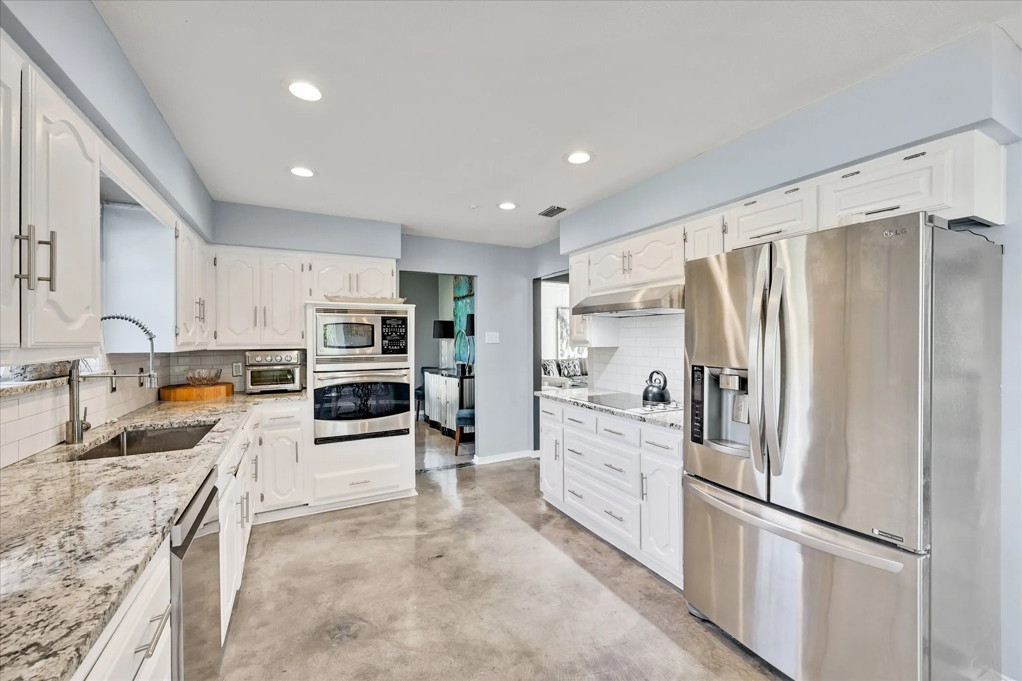 Tray ceiling with a decorative chandelier, light blue walls, and durable flooring
