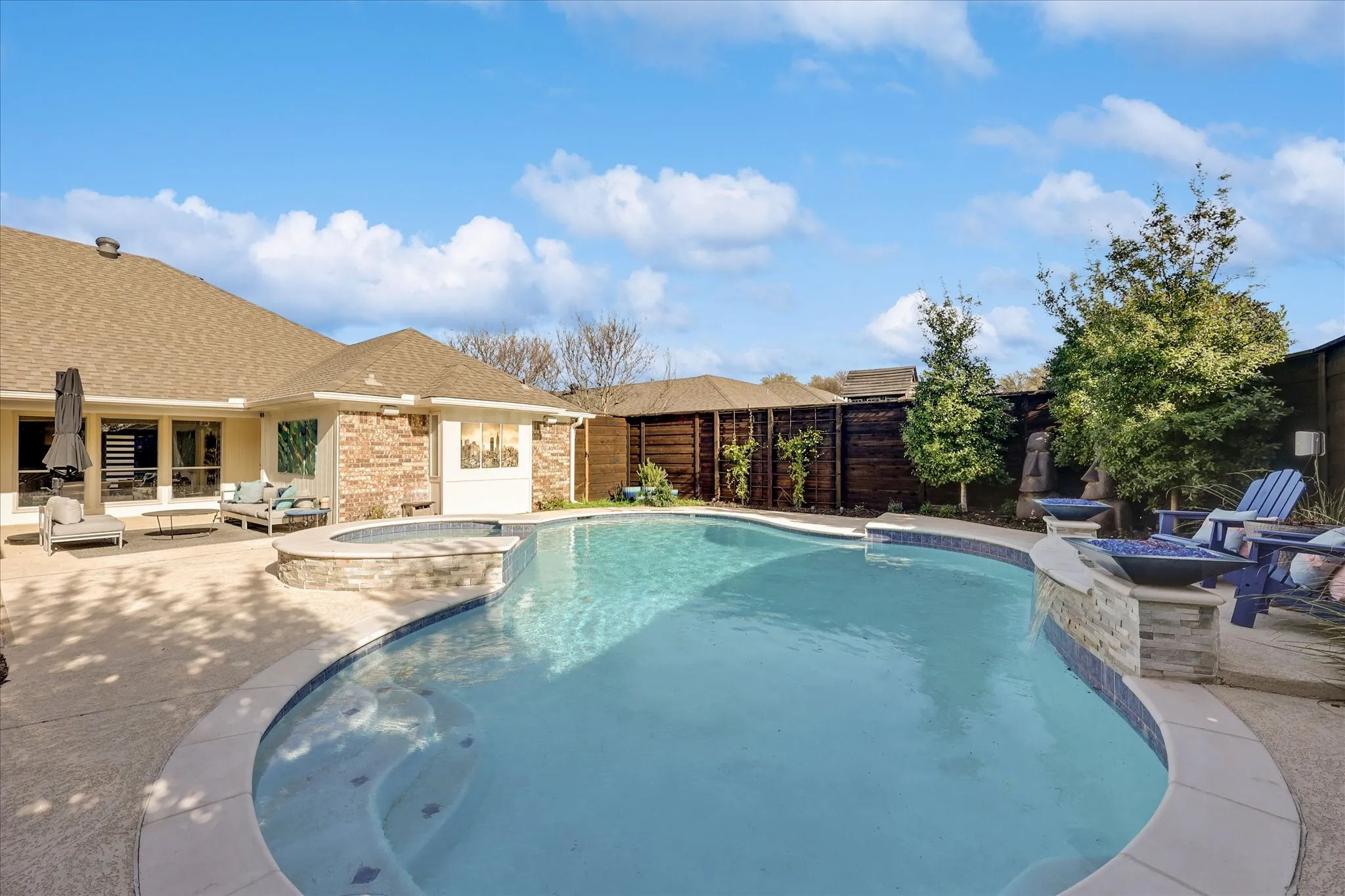 Expansive patio featuring a built-in outdoor kitchen with stainless steel appliances, an integrated television, and a covered entertaining area