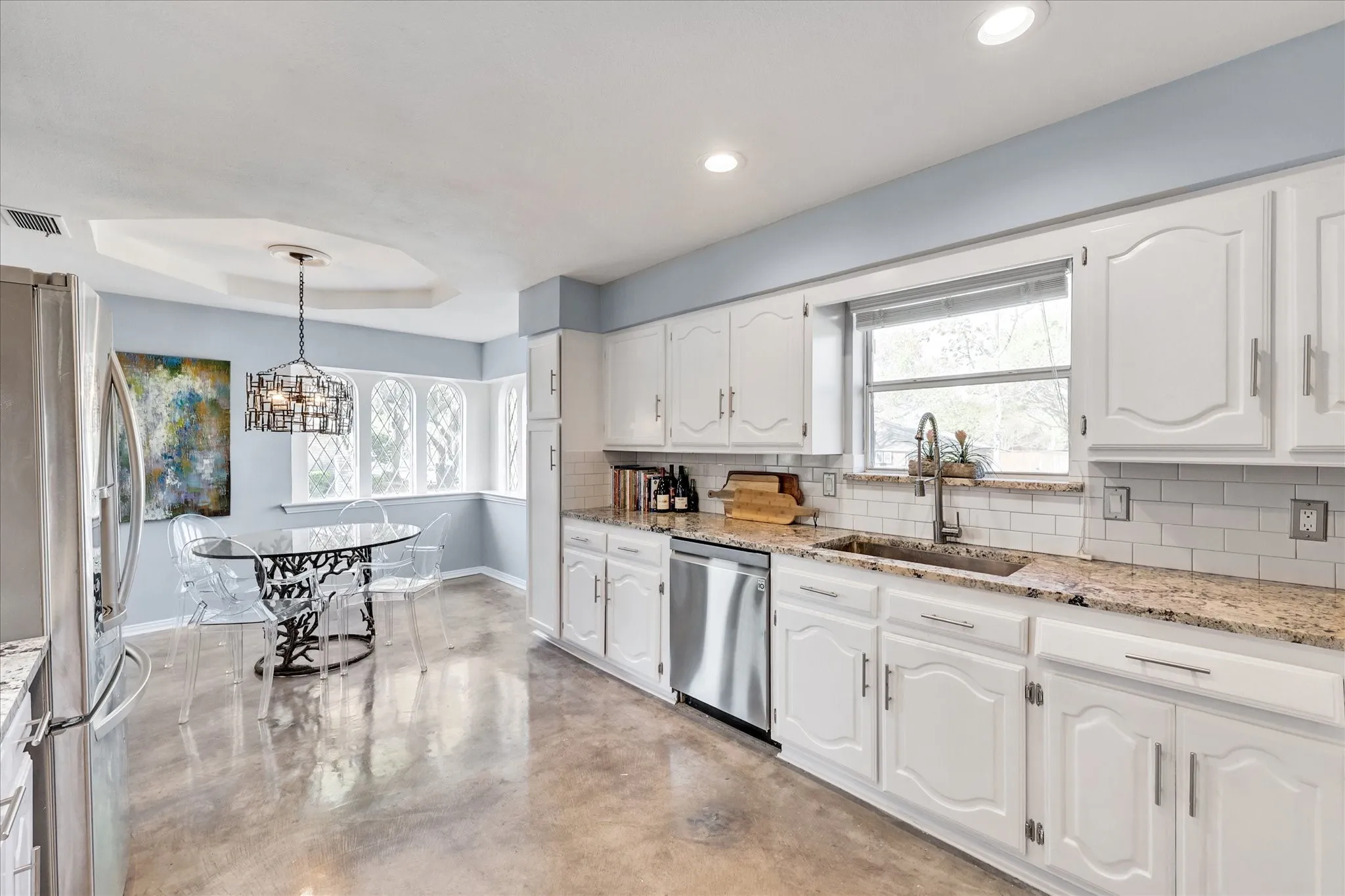 Kitchen featuring white cabinetry, stainless steel appliances, speckled stone countertops, a subway tile backsplash, and recessed lighting
