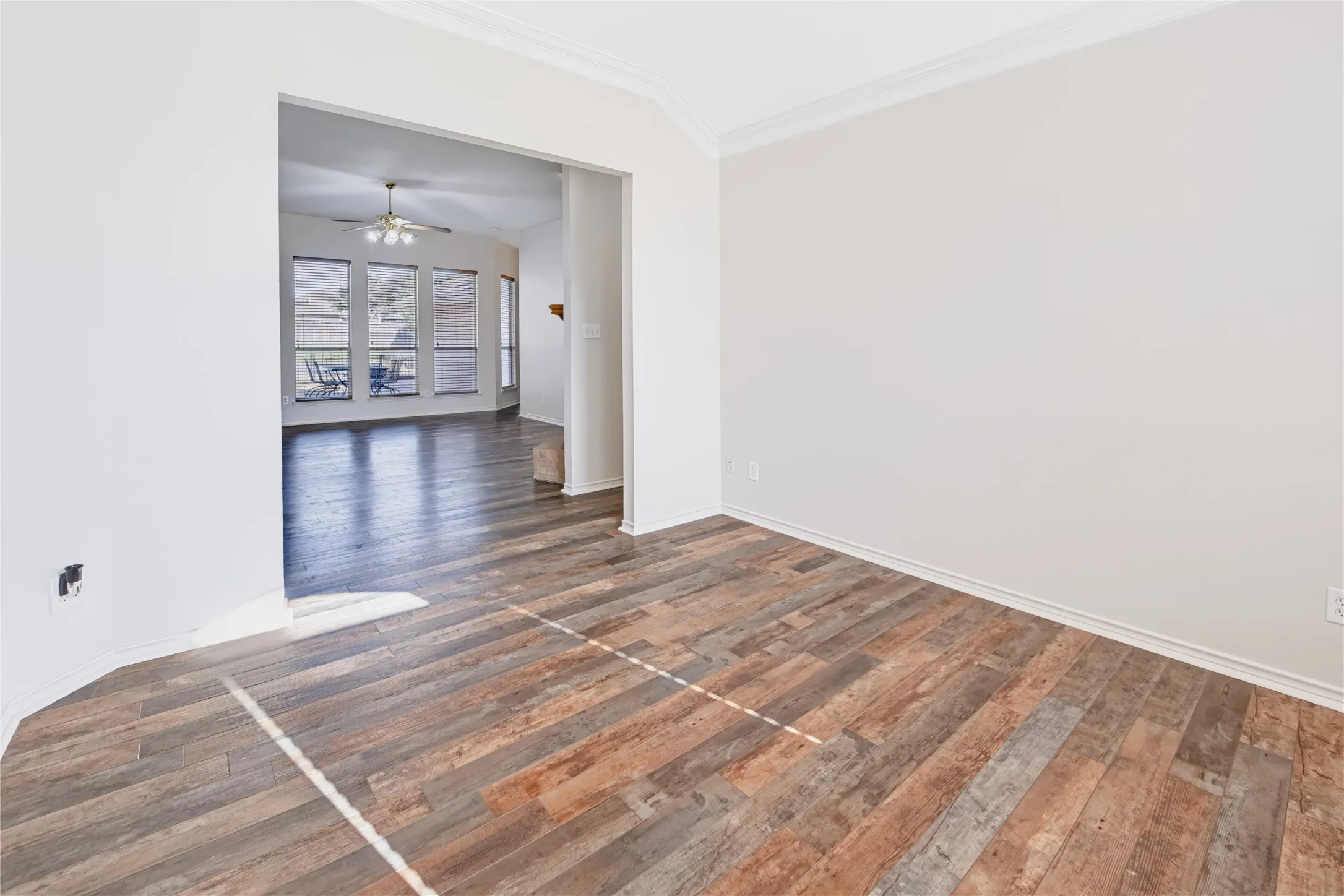 Wood-finish flooring, neutral wall tones, vaulted ceilings, and crown molding