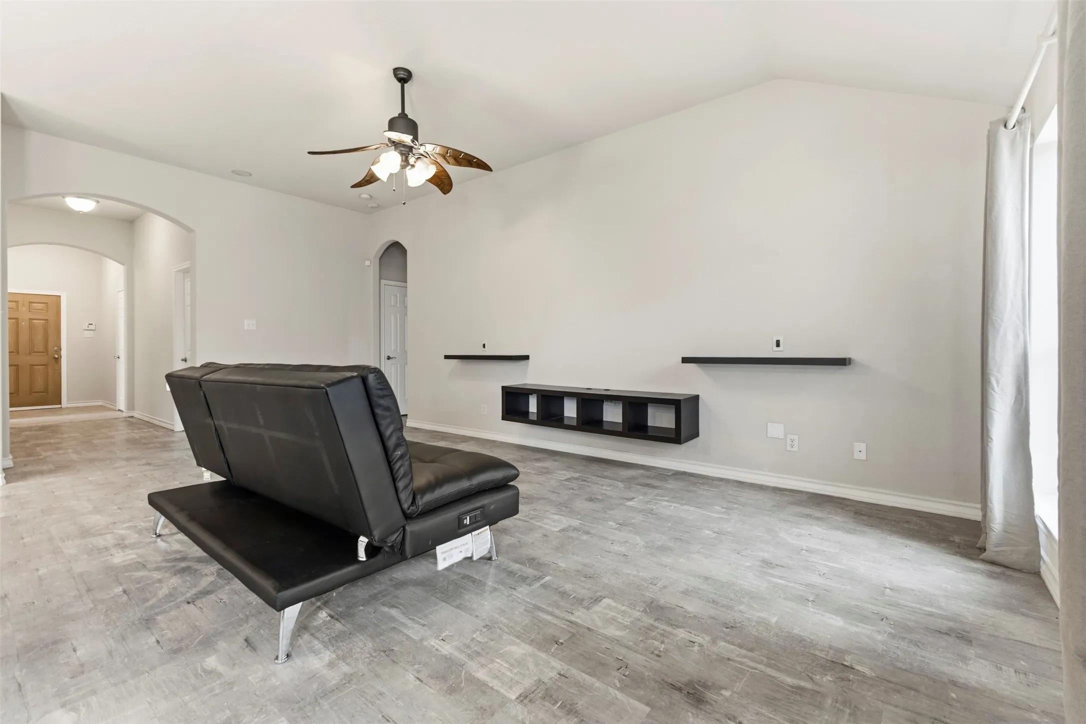 The beautifully arched foyer adds that custom home feel to the freshly painted living room.