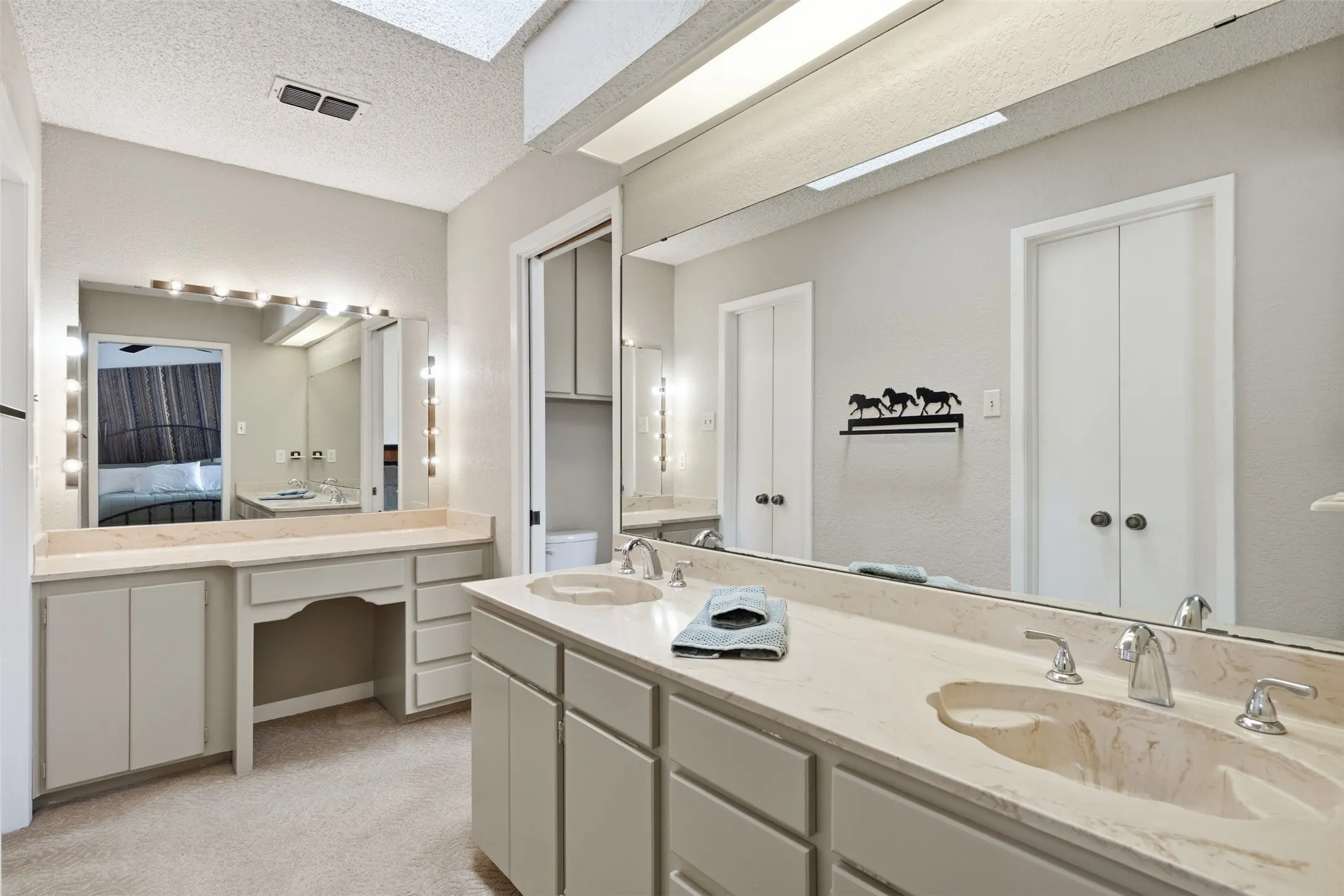 Dual sinks, make-up vanity, pocket door to walk-in shower.