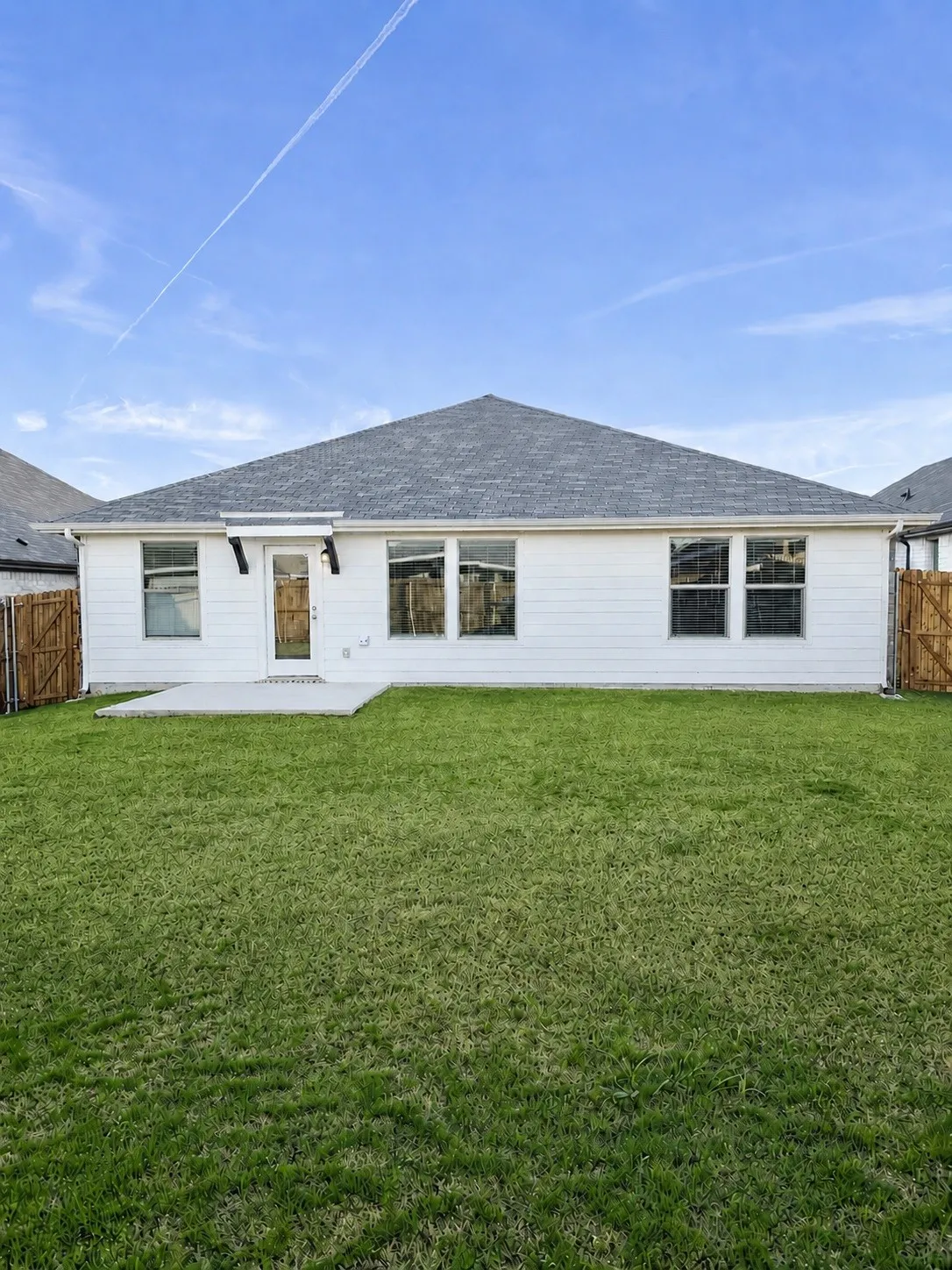 Expansive backyard with a concrete patio, and fenced perimeter