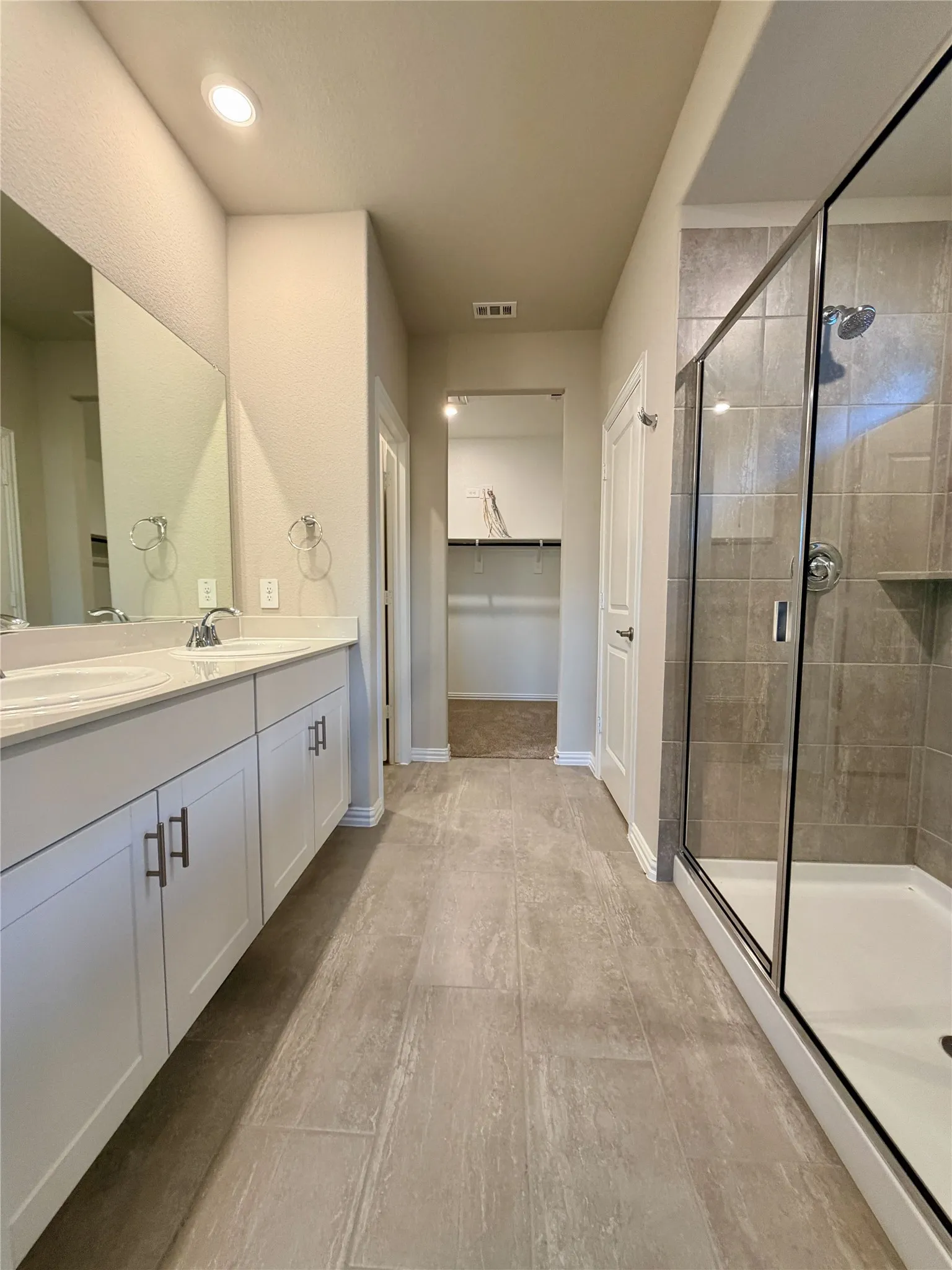 Dual vanity with white cabinetry, light-toned countertops, and undermount sinks