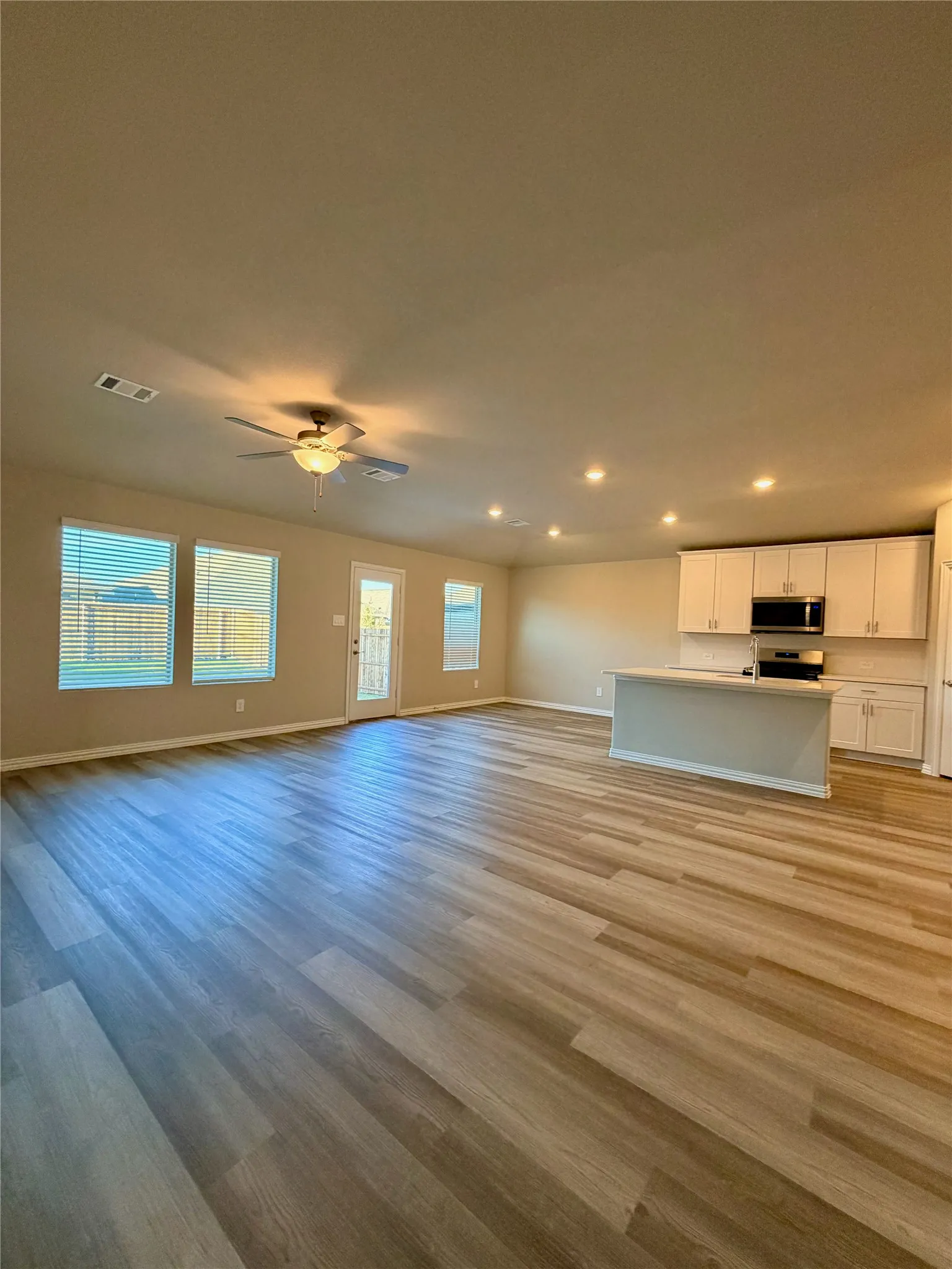 Open-concept living space featuring wood-finish flooring, recessed lighting, and a ceiling fan