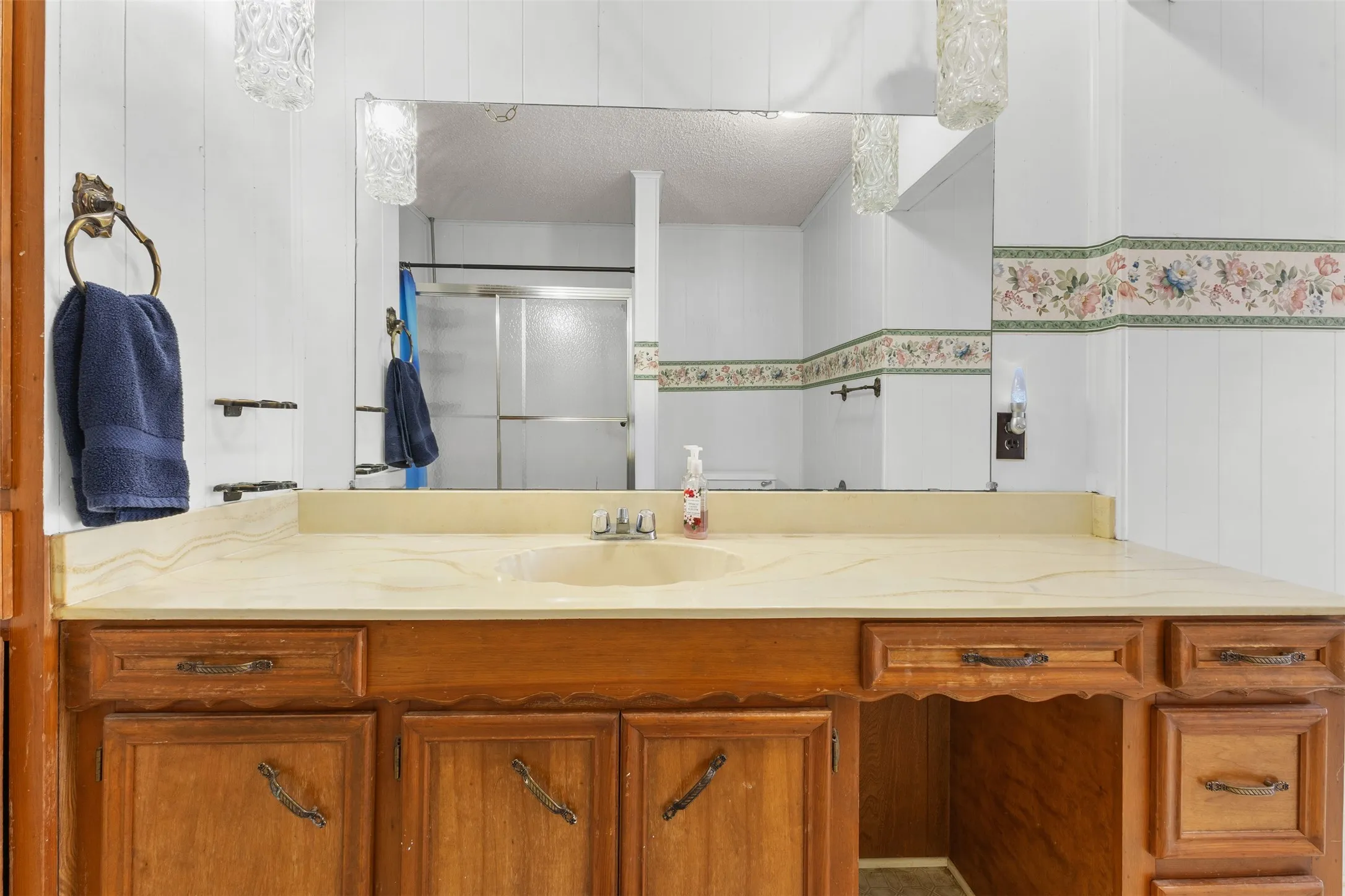Wood-finish vanity with an integrated sink and light-toned countertop