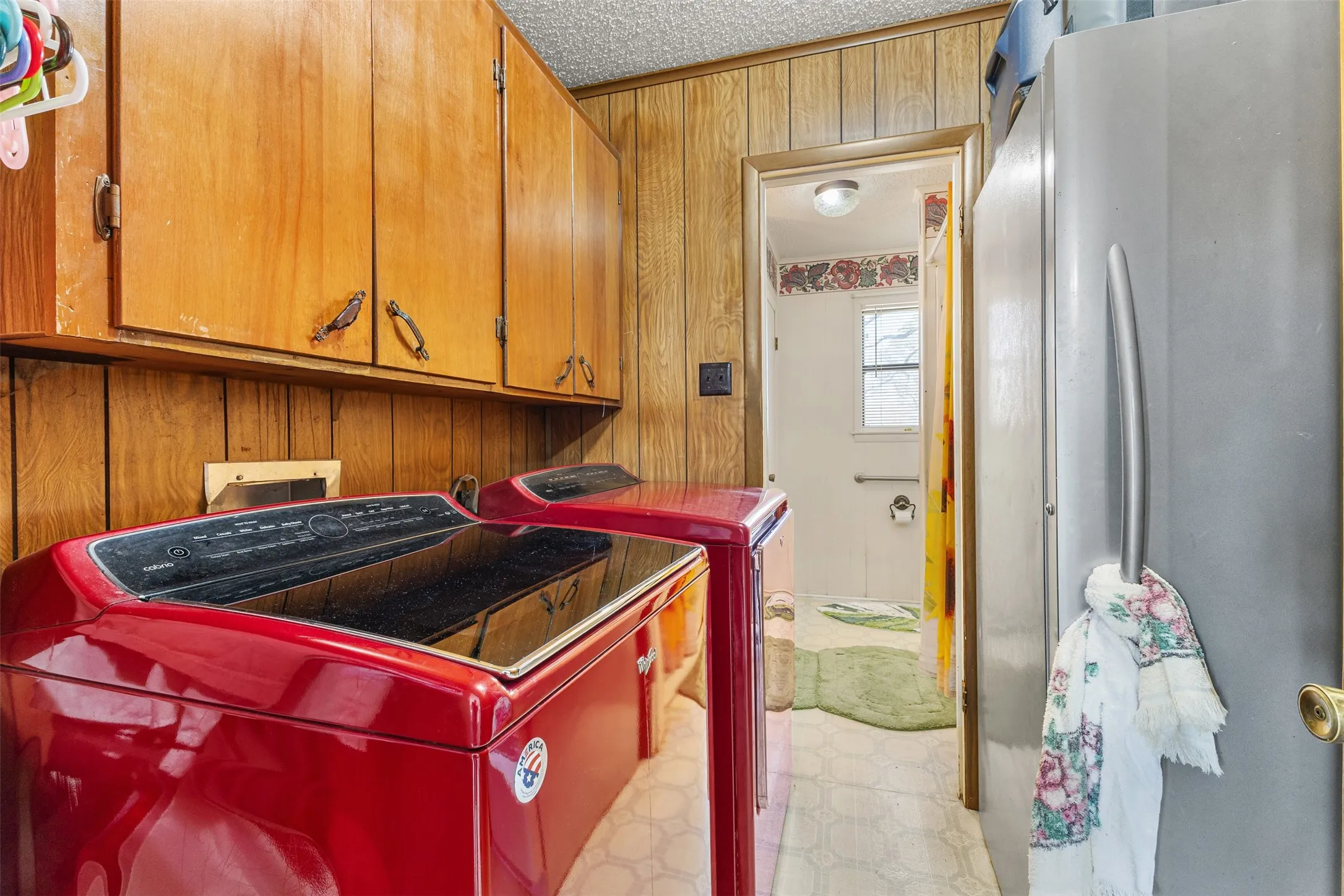 Wood-paneled wall, wood-finish cabinetry, and a vinyl flooring