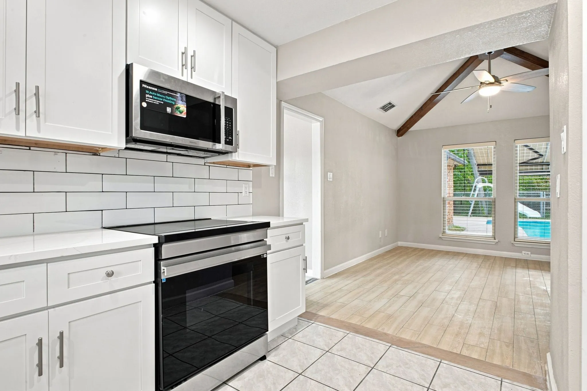 Updated kitchen with stainless steel appliances, white cabinetry, and subway tile backsplash